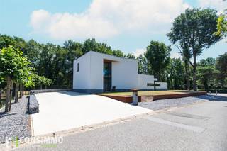 Bent u op zoek naar een moderne, instapklare villa met tijdloze architectuur, hoogwaardige afwerking en veel natuurlijk licht? Deze bijzondere woning aan de Neerzijstraat 28, gelegen in het gegeerde Bret-Gelieren, combineert rust, comfort en een toplocatie vlak bij alle voorzieningen.<br /><br /><strong>Indeling:</strong><br />Bij het binnenkomen via de royale inkomhal met vide en grote glaspartijen wordt meteen de toon gezet: licht, ruimte en verfijning voeren hier de boventoon. Vanuit de inkomhal bereikt u de elegante leefruimte, de open keuken, het gastentoilet en de trap naar de verdieping. De leefruimte is onderverdeeld in een gezellige zit- en eetkamer met zowel een gashaard als een houthaard – ideaal om een warme, huiselijke sfeer te creëren. De keuken is volledig ingericht met kwalitatieve inbouwtoestellen en grenst aan een handige berging en wasplaats met directe toegang tot de kelder. Deze kelder biedt extra opslagruimte, mogelijkheden voor hobby’s en plaats voor twee wagens in de inpandige garage.<br />Daarnaast bevindt zich op het gelijkvloers een afzonderlijke bureauruimte, perfect voor wie van thuis uit werkt of een aparte werkplek wenst.<br />Op de verdieping leidt de traphal met glazen wanden naar drie ruime slaapkamers en een badkamer. De master bedroom beschikt over een dressing, een privéterras en een ensuite badkamer met haard, inloopdouche, hoekbad, dubbele wastafel en toilet.<br /><br /><strong>Buitenruimte:</strong><br />De aangelegde tuin met overdekt terras en sfeervolle buitenhaard vormt een heerlijke plek om het hele jaar door te genieten in alle rust.<br /><br /><strong>Technische info:</strong><br />Deze architecturale villa is voorzien van aluminium ramen met driedubbele beglazing en behaalt een gunstig EPC-label B (115 kWh/m²). Verwarming gebeurt via vloerverwarming, een gashaard en een houthaard. De elektrische keuring is conform. Met een bewoonbare oppervlakte van 252 m² en een perceel van 8a 87ca geniet u hier van ruimte, comfort en kwaliteit.<br /><br /><strong>Ligging:</strong><br />De woning is gelegen in het exclusieve, groene Bret-Gelieren, een van de meest gewaardeerde wijken van Genk. U woont hier in een rustige, residentiële omgeving omgeven door natuur, met toch een vlotte verbinding naar het stadscentrum en de belangrijkste invalswegen. Scholen, winkels, openbaar vervoer en recreatiemogelijkheden bevinden zich op wandel- of fietsafstand. De buurt straalt klasse en toekomstwaarde uit, waardoor dit niet enkel een thuis is, maar ook een duurzame investering.<br /><br />Wordt deze moderne designvilla uw nieuwe thuis? Wacht niet langer en plan een bezoek via 089 69 30 01 of mail naar info@consimmo.be. Bekijk zeker ook de virtuele rondleiding op www.consimmo.be.