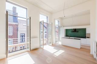 Stap binnen in een stukje industrieel erfgoed. Dit karaktervolle appartement maakt deel uit van de <strong>voormalige Dacca-fabriek, </strong>waar geschiedenis en hedendaags wooncomfort samensmelten tot een bijzonder woonproject. De monumentale inkomhal van de vroegere directeurswoning is volledig in ere hersteld en vormt nu de centrale inkomzone.<br /><br />Het appartement bevindt zich op de <strong>1ste verdieping</strong> en valt meteen op door zijn<strong> hoogwaardige afwerking</strong>. De warme parketvloer, hoge plafonds en originele moluren creëren een sfeervolle en elegante woonomgeving. Dankzij de recente schilderwerken is het appartement volledig instapklaar.<br /><br />De indeling biedt een <strong>ruime, lichtrijke woonkamer met hoge ramen</strong>, een prachtige geïnstalleerde open keuken met eiland en een aansluitende berging, <strong>twee volwaardige slaapkamers, </strong>een badkamer met inloopdouche, gastentoilet en een <strong>aangenaam zonneterras </strong>– ideaal voor wie houdt van ruimte en charme. Er werd bewust gekozen voor <strong>duurzame, kwalitatieve materialen</strong> die het unieke karakter van deze woning versterken. Parkeren doe je zorgeloos in de <strong>ondergrondse parking</strong>, bereikbaar via een handige autolift.<br /><br />Het appartement is <strong>beschikbaar vanaf 01/02/2027</strong> en dit voor een huurprijs van <strong>€1000/maand + €75/maand </strong>voor de algemene onkosten.<br /><em>Individuele tellers voor water, gas en elektriciteit. </em><br /><br />We zoeken een huurder die <strong>respect </strong>heeft voor dit bijzondere pand en de zorg voor de <strong>kwaliteitsvolle afwerking</strong> weet te waarderen.<br />Wil je dit unieke appartement zelf komen ontdekken? <strong>Bel Charlotte op 03/502.98.74 of mail naar cvg@claves.be voor een bezoek.</strong>