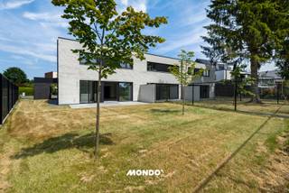 Ontdek deze rustig gelegen BEN-nieuwbouwwoning waar ruimte, comfort en energiezuinig wonen naadloos samenkomen. Met een bewoonbare oppervlakte van maar liefst 242 m² biedt deze stijlvolle woning alle hedendaagse wooncomfort op een uitstekende locatie, in de onmiddellijke nabijheid van winkels, scholen, openbaar vervoer en de belangrijkste verbindingswegen (A12, N16 en E19).<br /><br />Via de ruime inkomhal betreedt u de woning, waar u meteen wordt verwelkomd door een aangename lichtinval en een doordachte indeling. Op het gelijkvloers bevinden zich een gastentoilet en een bijzonder lichtrijke leefruimte met een volledig uitgeruste open keuken. Deze moderne keuken is afgewerkt met kwalitatieve toestellen, waaronder een inductiekookplaat met geïntegreerde dampkap, vaatwasser, oven, combi-microgolfoven, bordenverwarmer, koelkast met diepvriesvak en een dubbele spoelbak. Dankzij de grote raampartijen geniet u vanuit de leefruimte van een mooi zicht op de tuin en heeft u rechtstreeks toegang tot het aangelegde terras en de zuidwestelijk georiënteerde tuin, waar u de hele namiddag en avond in alle rust van de zon kunt genieten.<br /><br />Verder beschikt het gelijkvloers over een praktische berging met wasplaats, voorzien van een spoelbak en aansluitingen voor een wasmachine en droogkast. Daarnaast is er een extra polyvalente ruimte die volledig naar wens kan worden ingericht als bureau, fitnessruimte, hobbykamer of praktijkruimte voor de uitoefening van een vrij beroep.<br /><br />Op de eerste verdieping bevinden zich vier volwaardige slaapkamers, een nachthal, een afzonderlijk toilet en een technische berging. De ruime master bedroom beschikt over een eigen dressing en een ensuite badkamer met inloopdouche en wastafel. De tweede badkamer is uitgerust met een ligbad, een ruime inloopdouche en een dubbele wastafel, waardoor ook grotere gezinnen alle comfort genieten.<br /><br />Ook op technisch vlak voldoet deze woning aan de hoogste normen. Zo is de volledige woning voorzien van vloerverwarming en airconditioning in zowel de leefruimte als alle slaapkamers. Dankzij de zonnepanelen en de BEN-norm geniet u bovendien van een bijzonder energiezuinige woning met een laag energieverbruik en een optimaal wooncomfort.<br /><br />Ook buiten werd aan alles gedacht. De tuin is volledig aangelegd en omheind, het terras en de oprit zijn reeds afgewerkt. De volledige woning is afgewerkt met duurzame en kwalitatieve materialen, waardoor u zorgeloos kunt genieten van een instapklare nieuwbouwwoning.