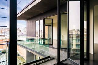 <p>Exclusieve loft met panoramisch uitzicht in de Theaterbuurt<br /><br />Wonen in een unieke loft, ontworpen door de gerenommeerde architect <strong>Vincent Van Duysen</strong>, op een toplocatie vlak bij de Botanische Tuin? Deze stijlvolle en uitzonderlijk ruime loft combineert tijdloze architectuur, hedendaags comfort en een bijzonder gevoel van ruimte en licht.<br /><br />Gelegen in de Theaterbuurt, bevindt u zich op wandelafstand van talrijke winkels, gezellige restaurants en andere voorzieningen. Het centrum ligt letterlijk aan uw voeten.<br /><br /><strong>Een loft met een uniek binnen-buitengevoel</strong><br /><br />Via de inkomhal betreedt u de ruime en <strong>lichtrijke leefruimte.</strong> Twee zijden van de leefruimte zijn voorzien van grote, volledig openklapbare ramen. Hierdoor vloeien interieur en terras naadloos in elkaar over en geniet u binnen van een heerlijk buitengevoel én een prachtig uitzicht over de daken van het stadscentrum.<br /><br />De<strong> open keuken met kookeiland </strong>is volledig uitgerust met de nodige toestellen en sluit rechtstreeks aan op het terras. Het ruime terras strekt zich uit over de volledige lengte van de keuken en leefruimte en vormt zo een ideale plek om te ontspannen of gasten te ontvangen.<br /><br /><strong>Twee slaapkamers, elk met eigen badkamer</strong><br /><br />De royale mastersuite omvat een ruime slaapkamer, een praktische dressing en een stijlvolle badkamer met wastafel, ligbad en toilet. De tweede slaapkamer beschikt eveneens over een eigen en-suite badkamer, uitgerust met een inloopdouche en wastafel.<br /><br />Verder beschikt de loft over een ruime berging in de hal, voorzien van aansluitingen voor wasmachine en droogkast, een vestiaire en een afzonderlijk gastentoilet met handenwasser.<br /><br />Extra troeven:<br />- Mogelijkheid tot het huren van <strong>autostaanplaats </strong>nr. 3 aan €120 per maand<br />- <strong>Inclusief kelderberging</strong><br />- Energiezuinige verwarming op gas<br />- Grote openklapbare ramen in HR-beglazing voor een uniek binnen-buitengevoel<br />- Strakke gietvloeren<br />- Mogelijkheid tot <strong>huren via een vennootschap</strong><br /><br />Een uitzonderlijke loft voor wie op zoek is naar architectuur, ruimte, comfort en een centrale topligging in één bijzonder geheel.</p>