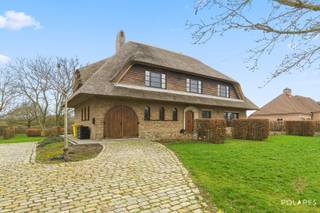 Aan de Heerbaan 62 in Kortenaken vindt u deze uitzonderlijke villa, waar rust, privacy en modern wooncomfort op harmonieuze wijze samenkomen.<br /><br />Gelegen op een indrukwekkend perceel van 25 are, biedt deze open bebouwing een zeldzaam gevoel van vrijheid, zowel binnen als buiten. De woning onderging in 2022-2023 een renovatie waarbij kosten noch moeite zijn gespaard: van een volledig vernieuwd dak en nieuwe raampartijen tot de installatie van zonnepanelen, wat resulteert in een energiezuinige woonervaring en een volledig conforme elektriciteit.<br /><br />Bij het betreden van de woning wordt u onmiddellijk verwelkomd door een royale inkomhal. De prachtige trap vormt hier het centrale pronkstuk en zet direct de toon voor de hoogwaardige afwerking die u in de rest van de villa terugvindt.<br /><br />De uiterst lichtrijke leefruimte is het hart van het huis; dankzij de grote raampartijen geniet u hier van een panoramisch zicht op de prachtig aangelegde, zuidgerichte tuin en het uitnodigende terras. De keuken is modern en volledig uitgerust en slim geschakeld met een praktische bureauruimte.<br /><br />De eerste verdieping ademt ruimte en comfort. Hier bevinden zich vier riante slaapkamers en een aparte dressing die aan al uw opbergwensen voldoet. De stijlvolle badkamer is een baken van rust, compleet ingericht met een dubbele lavabo, een ligbad en een moderne inloopdouche. Extra bergruimte is voorzien in de vorm van een handige bergzolder, en aangezien de woning volledig onderkelderd is, ontbreekt het u nooit aan plaats voor opslag of hobby’s.<br /><br />Buiten zet de luxe zich voort. De tuin is een waar paradijs waar u in alle privacy kunt ontspannen met een uniek zicht op de achtergelegen boomgaard. Er is verder een inpandige garage, terwijl de oprit parkeergelegenheid biedt aan meerdere wagens.<br /><br />Deze villa biedt een solide basis op een mooi domein, ideaal voor wie op zoek is naar een zorgeloze woning op een idyllische ligging met zicht op het groen.