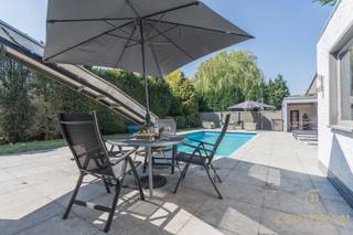 <p><strong>Altijd al willen "leven in weelde"? Dan is deze vrijstaande villa wellicht dé woning voor u!</strong><br /><br />In de grensgemeente <span><span>Weelde</span></span> bevindt zich deze gezellige en gerenoveerde vrijstaande villa met maar liefst vier ruime slaapkamers en een verwarmd buitenzwembad. Een ideale woning voor wie comfort, privacy en luxe wil combineren met ruimte en functionaliteit.</p>
<p>Bij binnenkomst treft u een inkomhal met aansluitend een bureau- of slaapkamer, perfect voor thuiswerk of gelijkvloers wonen. De woonkamer vormt het hart van de woning en biedt toegang tot de geïnstalleerde keuken en de gang. Via de gang bereikt u de zij-ingang, een gastentoilet en een extra logeerkamer.</p>
<p>De bijzonder ruime hoofdslaapkamer kijkt uit op de achtertuin en het zwembad en beschikt over een ensuite badkamer met ligbad, wastafel in meubel en een eigen toilet. De praktische bergruimte geeft via een afsluitbare schuifraam toegang tot het overdekte terras en de tuin.</p>
<p>Op de bovenverdieping leidt de vaste trap naar een royale overloop met toegang tot een ruime slaapkamer, een even ruime dressing en een luxueuze badkamer uitgerust met douche, dubbele wastafel, toilet en Finse sauna. Het aangrenzende terras beschikt over een unieke waterglijbaan die uitkomt in het met warmtepomp verwarmde zwembad. Het terras en de boordstenen zijn uitgevoerd in gebrande natuursteen, wat zorgt voor een stijlvolle en hoogwaardige uitstraling.</p>
<p>De volledig omheinde tuin garandeert optimale privacy en wordt vervolledigd door een gezellig barretje, een ruime garage en een automatisch bedienbare toegangs- en garagepoort.</p>
<h3>Pluspunten</h3>
<ul>
<li>
<p>Volledige privacy</p>
</li>
<li>
<p>Volledig omheind perceel</p>
</li>
<li>
<p>Verwarmd zwembad met waterglijbaan</p>
</li>
<li>
<p>2 badkamers en 4 slaapkamers</p>
</li>
<li>
<p>Mogelijkheid tot combinatie werk/wonen</p>
</li>
<li>
<p>Geïsoleerde kruipruimte</p>
</li>
<li>
<p>Aangelegd terras in gebrande natuursteen</p>
</li>
<li>
<p>CV-ketel vernieuwd (2026)</p>
</li>
<li>
<p>Ruime garage en oprit voor meerdere wagens</p>
</li>
<li>
<p>Centrale ligging, op een letterlijke steenworp van de Nederlandse grens</p>
</li>
<li>
<p>Vlakbij het gezellige Baarle-Nassau/Hertog en op korte afstand van Turnhout</p>
</li>
</ul>
<p>Een instapklare villa waar luxe, comfort en privacy centraal staan.</p>