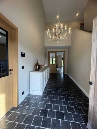 Deze statige villa werd gebouwd in 2016 met oog voor kwalitatieve materialen en comfort.<br /><br />Gelegen aan de Bouwelsesteenweg geniet deze woning van een uitstekende combinatie van bereikbaarheid en een groene omgeving. Via de steenweg zijn zowel Nijlen als Bouwel en de belangrijke verbindingswegen gemakkelijk bereikbaar. Bovendien liggen winkels, scholen, openbaar vervoer en allerhande dagelijkse voorzieningen in de onmiddellijke omgeving.<br /><br />De verzorgde oprit en de inkomhal met vide geven het geheel meteen een fraaie eerste indruk. De leefruimte dankt haar grandeur aan de hoge plafonds, de dubbele inkomdeur en de glazen wand met stalen frame die voor een vloeiende overgang zorgt tussen eet- en zitkamer. De ruime leefkeuken met een imposant keukeneiland is volledig geïnstalleerd. De keuken is uitgevoerd in een degelijk materiaalduo van hout en natuursteen en straalt een tijdloze duurzaamheid uit.<br /><br />De aangelegde en omheinde tuin met verwarmd zwembad en overdekte tuinpaviljoen voorzien van een gezellig gasvuur is een absolute meerwaarde. De volgroeide hagen zorgen voor een ongestoorde privésfeer. Het perceel heeft een totale oppervlakte van 11a 65ca en een mooie breedte van 30lm.<br /><br />De geïnstalleerde bureauruimte maakt de woning daarenboven interessant voor thuiswerkers.<br /><br />De rechtervleugel op het verdiep bestaat uit de masterbedroom met annex dressing en ruime ensuite badkamer met ligbad, dubbele douche, dubbele wastafel en toilet.<br /><br />Verder bestaat de eerste verdieping uit 2 slaapkamers, een tweede badkamer met inloopdouche en lavabo en een apart toilet.<br /><br />Het tweede verdiep is toegankelijk via een vaste trap. Deze extra ruimte is volledig afgewerkt en voorzien van maatkasten en airco.<br /><br />Ten slotte is er op het gelijkvloers een gastentoilet, een inpandige dubbele garage met een hydraulisch platformlift naar de ruime kelder, een aparte berging met maatkasten en wasvoorzieningen.<br /><br />De kelder is opgedeeld in verschillende compartimenten met onder meer een fitnessruimte en ontspanningsruimte.<br /><br />Kortom, een parel van een woning waarbij functionaliteit, luxe en ruimtelijkheid de voornaamste sleutelwoorden zijn.