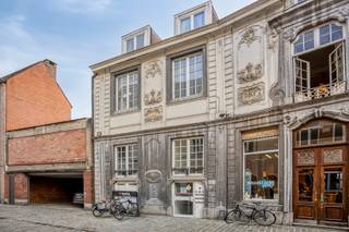 <h3>Uniek pand met atelier en woongelegenheid in hartje Leuven</h3>
<p>In het hart van Leuven, in de charmante Schrijnmakersstraat (“Schrènsstroot”), vlak naast de keuken van Dagelijkse Kost en om de hoek van de Mechelsestraat, bevindt zich dit ruime pand met een totale oppervlakte van ca. <strong>366 m²</strong>.</p>
<p>Achter de authentieke gevel bevindt zich op het gelijkvloers een ruime <strong>atelier-/handelsruimte van ca. 172 m²</strong>, voorzien van sanitair, aansluitingen voor een keuken, een aangename koer en toegang tot een kelder, ideaal als extra stockage. <strong>Het atelier is verhuurd tot 24/06/2029.</strong></p>
<p>De verdiepingen zijn momenteel ingericht als twee afzonderlijke woonunits, met oppervlaktes van ca. 88 m² en 106 m². Eén van de woonunits beschikt bovendien over een balkon.</p>
<p><strong>De stedenbouwkundig vergund geachte toestand </strong>omvat een atelier op het gelijkvloers en één zelfstandige woongelegenheid. De huidige indeling van de verdiepingen biedt, mede dankzij de ruime oppervlaktes, <strong>verschillende mogelijkheden voor de toekomstige eigenaar</strong>. Zo kan onder meer het <strong>kotmadamprincipe</strong> interessante mogelijkheden bieden. De concrete mogelijkheden dienen uiteraard verder te worden bekeken in functie van de geldende stedenbouwkundige voorschriften.</p>
<p>Het pand beschikt over een absolute topligging, op wandelafstand van de Grote Markt, de Mechelsestraat, winkels, horeca en alle voorzieningen die Leuven te bieden heeft.</p>
<p>Een bijzonder pand met <strong>veel ruimte, karakter en potentieel</strong>, ideaal voor wie op zoek is naar een combinatie van wonen en werken, een ruime stadswoning of een interessante eigendom op een toplocatie.</p>
<p>Interesse? Contacteer <strong>Anne-Leen op 0495 13 81 11</strong> voor meer informatie of een bezoek.</p>
