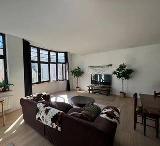 TE HUUR - GENT. Op een uiterst centrale ligging in Gent bevindt zich dit mooi afgewerkte appartement, waar licht, ruimte en comfort harmonieus samenkomen. Dankzij de hoogwaardige materialen en de verzorgde afwerking geniet u hier van een aangename en eigentijdse woonomgeving.<br /><br />Via de inkomhal betreedt u de ruime leefruimte, die baadt in natuurlijk licht dankzij de grote raampartijen. De centraal geïntegreerde, volledig ingerichte keuken sluit hier naadloos op aan en vormt een gezellige plek om te koken en te leven. De parketvloeren versterken de warme en stijlvolle uitstraling van het geheel.<br /><br />Verder beschikt het appartement over twee slaapkamers, een badkamer en een praktische wasruimte. Het aangename terras biedt een fijne buitenruimte waar het rustig vertoeven is.<br /><br />Dit appartement is de ideale keuze voor wie comfortabel en centraal wil wonen in Gent, met alle voorzieningen binnen handbereik.<br />Epc-label: B<br />Huurprijs: € 1.400/maand - Algemene kosten: € 50/maand