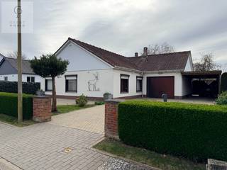 Deze gezellige bungalow op een perceel van 11a 63ca kom je niet vaak tegen.<br /><br />Voor meer informatie en alle foto’s, neem zeker een kijkje op onze website: www.pierco.be<br /><br />Gelegen in een rustige buurt en omgeven door groen, biedt deze bungalow een unieke combinatie van ruimte, rust en privacy.<br />De tuin vloeit als het ware over in het achterliggende landschap, wat zorgt voor een bijzonder aangenaam en open gevoel.<br /><br />De huidige eigenaars hebben deze woning jarenlang met veel plezier gebruikt als tweede verblijf en nemen dan ook met pijn in het hart afscheid van deze prachtige locatie.<br /><br />Bij aankomst valt meteen de rust en de openheid van het perceel op. De woning beschikt over een ruime oprit, een afgesloten garage en een praktische carport.<br /><br />We betreden de woning via de inkomhal aan de zijkant van de bungalow.<br />Zoals het een echte bungalow betaamt, bevindt alles zich op het gelijkvloers — een enorme troef voor wie comfortabel en toekomstgericht wil wonen.<br /><br />De inkomhal biedt plaats voor een vestiaire en een apart toilet.<br />Van hieruit bereiken we de nachthal, die toegang geeft tot drie slaapkamers en een badkamer, uitgerust met een tweede toilet, ligbad en lavabo.<br /><br />Aan de andere zijde van de woning bevindt zich de leefruimte, die dankzij de grote raampartijen een prachtig zicht biedt op de tuin en het omliggende groen. Een echte oase van rust.<br /><br />Aansluitend vinden we de open keuken, die naadloos overgaat in de veranda. Deze lichtrijke ruimte zorgt voor een aangename verbinding tussen binnen en buiten.<br /><br />Via de veranda hebben we toegang tot de garage en een aparte berging, waar zich de verwarmingsketel op aardgas bevindt.<br />De woning beschikt bovendien over een kruipkelder en een zolder, wat extra opbergruimte biedt.<br /><br />Vanuit de veranda stappen we zo het ruime terras op, met aansluitend de grote tuin waar je in alle rust kan genieten van het groene uitzicht.<br /><br />Ben je al een tijdje op zoek naar een bungalow of wens je comfortabel gelijkvloers te wonen met een ruime tuin? Dan is dit jouw kans.<br /><br />Neem gerust contact met ons op, wij leiden je met plezier rond in deze woning die je volledig naar eigen smaak kan omvormen.<br /><br /> 