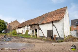 Deze totaal te renoveren vakwerkhoeve (lot 3 op verkavelingsplan) aan de Grote Baan te Hasselt (Kuringen) dateert van begin 19de eeuw. De aanwezige langgestrekte vakwerkhoeve is als monument beschermd met ID 2626. Tevens heeft deze ook een bescherming als stads- of dorpsgezicht (ID 2630).<br /><br />Het gebouw heeft een historische waarde als 19de eeuws relict, bestaande uit een kern uit 1843 die in 1883 verder uitgebreid werd. Van deze orginele oude kern blijven tot op heden nog maar slechts twee traveeën over na oorlogsschade van 1940-1945. In latere fases werden er nog toevoegingen gedaan die geen meerwaarde betekenen voor de erfgoedwaarden en zelfs storend worden ervaren.<br /><br />De hoeve beschikt over één bouwlaag onder een pannen (rode handvorm boomse dakpan) zaldeldak met een afgewolfde westzijde. De oversteekkepers aan de noord(straat)zijde zijn opgebouwd uit horizontale klossen met een houten beboording. Aan de zuid- en westzijde zorgen de overstekende dakkapers voor de nodige bescherming van het leemwerk.<br /><br />Boven het woongedeelte en de oostelijke stel is een zolderruimte aanwezig die momenteel niet toegankelijk is wegens de slechte staat.<br /><br />De toegangsdeur van het hoeve is in de achtergevel gelegen.<br /><br />Hoofdbestemming: restaurant, café, kantoorfunctie, dienstverlening en vrije beroepen zijn toegelaten. Een combinatie van deze functies is eveneens toegelaten. Wonen als hoofdbestemming is NIET toegelaten.<br />Nevenbestemming: ondergeschikt zijn nevenbestemmingen inherent aan het functioneren van de hoofdbestemming zijn toegelaten. Bijkomend is wonen als nevenbestemming bij de op te richten hoofdbestemming toegelaten.<br /><br />De onmiddellijke omgeving van de vakwerkhoeve is beschermd als dorpsgezicht o.w.v. het algemeen belang gevormd door de sociaal culturele waarde. De historische percelering met grasland langs de erfzijde en een haag op de noordelijke perceelsgrens, langs de straatzijde, bepaalt mee het landelijke karakter van de hoeve en vormt een ondersteuning van de agararische erfgoedwaarden.<br /><br />Het perceel is zuid georiënteerd, heeft een perceeloppervlakte van 1507 m² en een gevelbreedte van 25m.<br /><br />Enkele troeven op een rij:<br />+ Langgestrekte vakwerkhoeve, beschermd monument van 15-06-2009 (https://id.erfgoed.net/aanduidingsobjecten/2626)<br />+ De vakwerkhoeve is aangeduid als vastgesteld bouwkundig erfgoed (https://inventaris.onroerenderfgoed.be/erfgoedobjecten/22239) en beschermd stads- of dorpsgezicht (https://inventaris.onroerenderfgoed.be/aanduidingsobjecten/2630)<br />+ Uitbreidingsmogelijkheden zijn toegelaten in samenspraak met het Agentschap Onroerend Erfgoed<br />+ De nutsvoorzieningen zijn afgesloten<br /><br />Ben je benieuwd naar de mogelijkheden van deze vakwerkhoeve? Neem dan contact op via stephanie@vestio.com of op 0474-73 64 84.
