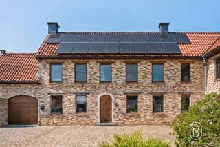 Ruim karakteristiek huis met 4 slaapkamers, een grote tuin en authentieke charme. Dit uitzonderlijke pand combineert de charme van een authentieke kleine boerderij met het comfort van een recente uitbreiding uit 2013. Met een woonoppervlakte van maar liefst 522 m² (te verifiëren aan de hand van het PEP), een perceel van 1 726 m² en een veelzijdige indeling is dit huis ideaal voor grote gezinnen, zelfstandigen of mensen die op zoek zijn naar een unieke woonervaring met veel ruimte.Indeling: entreehal, kantoor, apart gastentoilet, een grote, lichte woonkamer, een kantoor met mezzanine, bijkeuken/wasruimte, badkamer, keuken en een tweede gezellige woonkamer. Dankzij de praktische indeling is het bovendien mogelijk om op de begane grond een slaapkamer in te richten.Op de eerste verdieping bevinden zich vier ruime slaapkamers, een tweede badkamer, een wellnessruimte met infraroodsauna, een inloopkast, een terras grenzend aan de ouderslaapkamer en een bibliotheek/kantoor. Daarnaast beschikt het huis over een ruime en volledig geïsoleerde zolder, ideaal als extra opslagruimte.Buiten kunt u genieten van een prachtige tuin met verschillende terrassen en een eigen boomgaard met onder andere vijgen-, appel-, kersen-, perzik- en pruimenbomen. Het huis beschikt tevens over een garage en een ruime parkeerplaats die plaats biedt aan meerdere auto’s.Het oorspronkelijke linkergedeelte van het huis heeft zijn authentieke karakter behouden, terwijl het rechtergedeelte in 2013 volledig is herbouwd en zowel op de begane grond als op de eerste verdieping is voorzien van vloerverwarming op aardgas. De hoofdslaapkamer en de bibliotheek zijn voorzien van airconditioning.Het huis straalt veel karakter uit dankzij de hoogwaardige en unieke afwerking, met onder meer prachtige binnendeuren vervaardigd uit deuren afkomstig van Indiase tempels en een gevarieerde keuze aan materialen zoals travertijn in de inkomhal, parket, leisteen in het kantoor, blauwe hardsteen aan de buitenkant en karaktervolle kasteeltegels in de tweede zitkamer. Bovendien zorgen de geïnstalleerde zonnepanelen voor een meerwaarde op het vlak van energie-efficiëntie. Te koop via Immo Beguin, uw vastgoedexpert sinds 2009.Meer informatie of een bezichtiging? Neem contact op met emmy@immobeguin.be