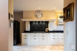 INDELINGVia de centrale inkomhal met elegante trappenhal bereikt u de ruime, landelijke leefkeuken met werkblad in blauwe hardsteen, uitgerust met...