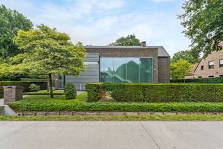 Welkom in deze stijlvolle en instapklare villa waar ruimte, licht en luxe naadloos samenkomen. Gelegen op een prachtig perceel van circa 1.570 m², biedt deze eigentijdse woning alles voor wie comfortabel en sfeervol wil wonen – binnen én buiten.<br /><br />Bij binnenkomst word je verwelkomd in een ruime open inkomhal met gastentoilet en vestiaire. De gelijkvloerse verdieping straalt gezelligheid en klasse uit dankzij de combinatie van grote raampartijen, een open haard, vloeren in Belgische blauwe hardsteen en warme parket. De open keuken is een ware eyecatcher: uitgerust met een royaal kook- en werkeiland, koelkast, oven, vaatwasser, microgolf, keramische kookplaat, grillplaat en zelfs een ingebouwd stoommandje. Aangrenzend vind je een praktische bijkeuken met ingemaakte kasten.<br />De eetruimte biedt voldoende plek voor een grote eettafel en een gezellige leeshoek. Aan de andere kant van de keuken is de zitruimte met open haard en aansluitend bevindt zich een lichtrijke bureauruimte, afgewerkt met maatkasten en zicht op de tuin – ideaal voor thuiswerk in stijl.<br /><br />De eerste verdieping ademt dezelfde hoogwaardige afwerking als het gelijkvloers. De nachthal verbindt vier slaapkamers. De master bedroom beschikt over een eigen dressing en een luxueuze ensuite badkamer met bad, inloopdouche en wastafel, en biedt een prachtig uitzicht op de tuin. De drie kinderkamers zijn stuk voor stuk voorzien van ingebouwde kasten en ingebouwde bureaus. Verder vind je hier een tweede douchekamer, een aparte wasplaats en een afzonderlijk toilet.<br /><br />Via een vaste arduinen trap bereik je de volledig afgewerkte zolderverdieping. Een ideale plek voor een extra slaapkamer(s), speelkamer, hobbyruimte of creatieve studio. Daarnaast is er een afgesloten bergzolder.<br />Tevens kelder aanwezig van ca 60m².<br /><br />De zuidoost gerichte tuin heeft meerdere terrassen en een verwarmd overloopzwembad met waar je op zonnige dagen heerlijk kunt genieten. Aan het zwembad een poolhouse met toilet, kleedruimte, ingebouwde toog en een buitendouche. <br />Achteraan het perceel vind je een ruime, stenen tuinberging met houtopslag én een dubbele carport. Voor de woning is er bovendien voldoende extra parkeergelegenheid.<br /><br />Buitengewone kenmerken: <br />•Hoogwaardige afwerking en veel maatwerk<br />•Grote raampartijen zorgen voor een prachtige lichtinval en tuinzicht<br />•4 slaapkamers en 2 badkamers, mogelijkheid tot extra slaapkamers<br />•Inpandige bergingen en multifunctionele zolderverdieping<br />•Verwarmd overloopzwembad <br />•Regenwaterput aanwezig<br />•Dubbele carport en extra parkeergelegenheid<br /><br />Deze woning combineert modern comfort met een warme, huiselijke sfeer. Ben je op zoek naar een instapklare woning met karakter en ruimte op een toplocatie? Dan is dit jouw nieuwe thuis. Neem vandaag nog contact met ons op voor een bezichtiging.