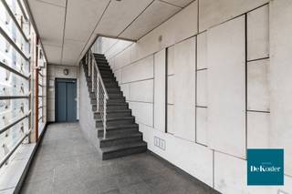 Dit stijlvolle duplexappartement is gelegen op de eerste en tweede verdieping van een kleinschalige, goed onderhouden residentie, LA LUNA genaamd. Het appartement combineert comfort, licht en kwaliteit. Het gebouw beschikt over een lift die uitkomt op een open passerelle. De gemeenschappelijke delen zijn smaakvol afgewerkt met natuursteen, wat meteen een verzorgde en kwalitatieve indruk geeft.<br /><br />Bij het betreden van het appartement komt u terecht in een ruime inkomhal met vestiaire, gastentoilet en een praktische berging met technische voorzieningen. Aan de achterzijde bevinden zich twee volwaardige slaapkamers, evenals een aparte berging met aansluiting voor wasmachine en droogkast. De ruime badkamer is volledig ingericht en afgewerkt met stijlvolle meubels in hoogglanslak.<br /><br />Via een open trap met glazen balustrade bereikt u de bovenverdieping. Hier bevindt zich aan de achterzijde een strak vormgegeven, volledig geïnstalleerde witte keuken. De keuken sluit naadloos aan op de eetruimte en geeft samen toegang tot een ruim en zonnig terras van maar liefst 24 m².<br /><br />Aan de voorzijde bevindt zich de ruime en gezellige leefruimte. De open indeling en glazen valbescherming zorgen voor een luchtig en ruimtelijk gevoel doorheen het volledige appartement.<br /><br />Als troef beschikt dit appartement over een ruime garagebox. Deze kan aangekocht worden aan €28.000,-.<br /><br />De gemeenschappelijke kosten bedragen €100,-/maand.