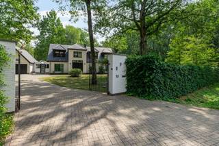 <p><span>Deze ruime villa (372m²) op een prachtig groen perceel (3.174m²) combineert een aangename architectuur met veel lichtinval en een uitzonderlijk veelzijdige indeling.</span></p><p><span>Een ideale thuis voor wie ruimte, privacy en groen weet te waarderen.</span></p><p><span>Via de ruime inkomhal met open trap betreden we de woning. Deze geeft ons vervolgens toegang tot de lichtrijke leefruimte. Deze geniet dankzij de grote raampartijen van een mooie verbinding met de tuin en biedt alle ruimte voor een gezellige zit- en eetkamer. De houthaard is hier ook een garantie voor gezellige en vooral warme winteravonden!</span></p><p><span>Aansluitend aan de leefruimte bevindt zich de open ingerichte keuken, welke is voorzien van meer dan voldoende werkblad- en kastruimte en de volgende toestellen: kookplaat, dampkap, vaatwasser, spoelbak, oven, combioven (microgolf - oven) en koelkast. Verder vinden we hier ook nog een verscholen koffiecorner en een aangename ontbijthoek met een prachtig zicht over de tuin (met zwembad). Naast de keuken bevindt zich nog een praktische en bijzonder ruime bijkeuken. Hier vinden we nog extra bergruimte, een microgolfoven en ook de voorzieningen voor wasmachine en droogkast.</span></p><p><span>Een absolute troef is de gelijkvloerse slaapvleugel. De ruime master charmeert met haar hoge plafond, karaktervolle schouw en rechtstreeks contact met de tuin (met vijver). Aansluitend bevinden zich een ingerichte dressing en een stijlvol vernieuwde badkamer met ligbad, ruime inloopdouche, dubbel lavabomeubel en toilet.</span></p><p><span>Verder vinden we op het gelijkvloers ook nog een tweede inkom, alwaar we het gastentoilet vinden en de toegang naar een extra berging. Hier vinden we ook de trap naar de kelderruimte, welke U ook nog heel wat bergruimte biedt.</span></p><p><span>Ook op de verdieping blijven ruimte en licht het sleutelwoord. Hier komen we allereerst bij een bijzonder lichtrijke, ruime bureauruimte met een prachtig zicht op het omliggende groen. Verder vinden we hier ook nog twee slaapkamers en een tweede volwaardige badkamer terug. Deze laatste is voorzien van een ligbad, douche, dubbel lavabomeubel en toilet.</span></p><p><span>Aan parkeergelegenheid op eigen terrein geen gebrek. Niet alleen beschikt de woning over een dubbele garage, ook op de ruime oprit kan men de nodige wagens kwijt.</span></p><p><span>Buiten geniet men van een volwassen, groene tuin die de woning ontzettend veel privacy en een heerlijk gevoel van rust geeft. In de tuin vinden we naast verscheidene gezellige terrassen ook een zwembad en een vijver terug, net als de nodige tuinbergingen en de technische ruimte van het zwembad.</span></p><p><span>Kortom, een verrassend ruim eigendom waar wonen, thuiswerken en ontspannen moeiteloos samengaan. Een unieke opportuniteit voor wie ruim en groen wil wonen!</span></p><p><span>Is uw interesse gewekt? We, dan hoor ik graag van U.</span></p>