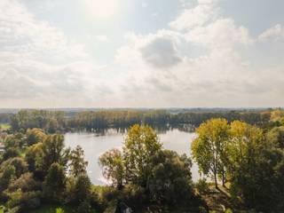<p>Ligging<br />Aan de rand van De Pinte, in een rustige en groene omgeving, staat deze klassieke vrijstaande villa in warme handvormsteen met witte luiken. De woning ligt op een royaal perceel van ± 1.238 m², met een diepe tuin en een ongestoord zicht op de prachtige vijver. Rust, ruimte en natuur liggen hier aan je voordeur, terwijl Gent en de belangrijkste invalswegen vlot bereikbaar blijven.<br /><br />De Woning<br />De villa werd gebouwd in 1995 en heeft een bewoonbare oppervlakte van ± 190 m² (volgens EPC). Ze is meteen bewoonbaar en biedt alle ruimte om er stap voor stap je eigen accenten te leggen.<br /><br />Interieur<br />Een ruime inkomhal opent naar een aparte bureauruimte, de leefruimte en de keuken. De lichte living draait helemaal rond het uitzicht: het grote schuifraam opent naar het overdekte terras, met de tuin en de vijver als decor. De afzonderlijke keuken heeft een klassieke afwerking en veel bergruimte. De ruime inpandige garage maakt het gelijkvloers af.<br />Op de verdieping liggen vier lichte slaapkamers, een badkamer met ligbad en dubbele lavabo en een aparte douchekamer met lavabo. Via een uittrekbare trap bereik je een ruime zolder, ideaal als bergruimte.<br /><br />Exterieur<br />De villa ligt op een diep perceel, omzoomd door hagen, met een overdekt terras en een zicht op het water dat je zelden vindt. Vooraan is er een ruime oprit voor meerdere wagens.<br /><br />De vijver<br />Vanuit de woning en de tuin kijk je uit op de vijver. Het beeld verandert met de seizoenen: frisgroen in de lente, lange zomeravonden aan het water, herfstkleuren die zich in het water spiegelen, en een stille nevel op een winterochtend. Een uitzicht dat de woning een bijzonder karakter geeft.<br /><br />Een instapklare woning op een unieke plek, met ruimte om er je eigen accenten te leggen.<br /><br />Verkoopprocedure<br />Deze eigendom wordt verkocht via een biedingsprocedure. De instelprijs bedraagt € 600.000 excl. kosten.</p>