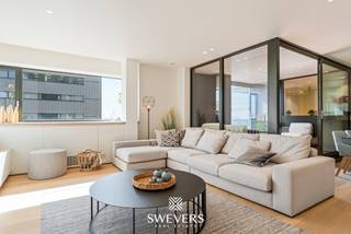 Voor meer info en foto’s, surf naar www.swevers.be – Hoog boven de stad, op de 11de verdieping van de gekende TT-torens, ontdekt u dit volledig gerenoveerde appartement waar niets nog moet gebeuren, buiten het uitpakken van uw koffers. De totaalrenovatie van 2024 zorgde voor een bijzonder hoogwaardige afwerking met strakke materialen en overal handig ingebouwde kasten. U geniet er van een lichtrijke leefruimte met open, volledig ingerichte keuken, twee volwaardige slaapkamers, een stijlvolle badkamer, een ruime berging en een aangenaam terras met weids uitzicht over de skyline van Hasselt. Op technisch vlak is alles bij de tijd, met industriële airconditioning, een lucht-luchtwarmtepomp en hoogrendementsbeglazing, terwijl het gebouw over meerdere liften en een ondergrondse parkeergarage beschikt. En dan is er de ligging: middenin het centrum van Hasselt, op wandelafstand van de winkelstraten, het Dusartplein en het bruisende uitgaansleven, met vlotte verbindingen naar station en invalswegen. Een unieke plek op vlak van luxe, comfort en rust, met een uitzicht dat u nergens anders vindt. Zin om het zelf te ontdekken of nood aan meer informatie? Bel 011 255 155. Bron bewoonbare oppervlakte: EPC – verslag.