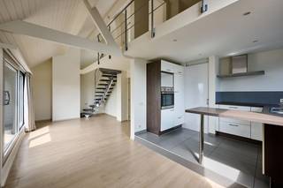 Op een zeer praktische locatie met uitstekende verbindingen kan u dit stijlvol duplex appartement terugvinden in een compacte Residentie. Traditioneel gebouwd in 1977 , gelegen op de bovenste verdieping en ondertussen volledig gerenoveerd beschikt dit appartement over een ruime 90m2. Een weldoordachte indeling creëert een aangenaam woongevoel met veel natuurlijke lichtinval en hoge plafonds met een open trap naar de mezzanine. Omvattend ; een royale inkomhal met toilet, open ingerichte designkeuken, ruime living, een eerste slaapkamer op hetzelfde niveau, mezzanine met 2 lokalen waarvan 1 als bureel en 1 als slaapkamer kan worden ingericht. het zuid gericht terras met volledige privacy heeft een prachtig zicht op de groene gemeente. De vermelde prijs is een " vanafprijs ". Bieden kan vanaf 300.000€. Biedingen vanaf dit bedrag worden in overweging genomen. De verkoper behoudt zich het recht van gunning voor. Contacteer ons op 02/569 99 99 voor meer inlichtingen of een persoonlijk bezoek ter plaatse.