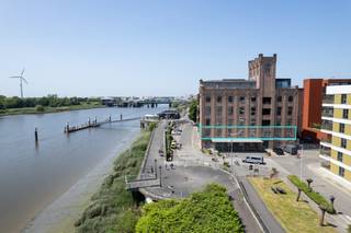 Zéér ruime loft 360m² op volledige eerste verdieping, in een karaktervol stenen gebouw van de voormalige Molens Rypens (industrieel bouwkundig erfgoed), gelegen aan de Rupel met een uniek en rustgevend uitzicht op het water en de sluis van Klein-Willebroek. Deze loft is thans samengevoegd tot één geheel, maar bestaat juridisch eigenlijk uit 2 kavels welke apart kunnen verkocht worden en gescheiden van elkaar. Indeling : Inkom met ingemaakte en modulaire kasten, luxueus ingerichte open keuken, voorzien van alle hoogwaardige toestellen, nachthall, zéér ruime woonkamer (123m²) met ingemaakte modulaire kasten en uniek en rustgevend uitzicht op het water, SLK 1/master met ingemaakte kasten en een 1e badkamer met vrijstaand ligbad, dressing, inloopdouche, SLK 2 of logeerkamer, wasplaats, bureau met ingemaakte kasten, deels gebouwd als inpandig terras met schuifraam : Deze schuifraam kan verwijderd worden om opnieuw een inpandig 'open terras' te creëren, SLK 3 en 4, elk met ingemaakte kasten en luxueus ingerichte 2de badkamer. Mogelijkheid tot aankoop ondergrondse dubbele autostaanplaats voor 2 wagens (achter elkaar). Inrichting : Volledig 'trendy' afgewerkt met gietvloeren, ingemaakte kasten, aangepaste verlichting, ..., kortom een pareltje om te wonen en beleven. Het interieurontwerp van Ar. Danny Venlet is doordacht daar het open geheel met aparte zones werd ingericht , die elk hun eigen sfeer en intimiteit krijgen, versterkt door een subtiel spel van niveauverschillen, materiaalgebruik en bestudeerde verlichting. Toplocatie aan Kaai - Bassinstraat met zicht op het water en de sluis van Klein-Willebroek. Gelegen op wandelafstand van het centrum, winkels, scholen & openbaar vervoer (bus en trein). Zéér centraal gelegen op slechts 3' van A-12, op een boogscheut van Antwerpen en Brussel. Interesse in een bezoek, bel ons kantoor : 03.459.99.99 of mail joeri@leximmo.be .