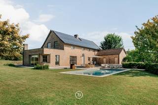 Deze eigendom wordt verkocht via het “Close the Deal”-systeem met een startprijs van € 895.000.<br />Elke kandidaat-koper kan een bod uitbrengen boven deze startprijs tot dinsdag 14 juli 2026 om 18u00. <br />Nadien kan de verkoop worden toegewezen aan de hoogste bieder.<br /><br />Uniek bezoekmoment: zaterdag 11 juli 2026 van 10u00 tot 12u00 (op afspraak).<br /><br />Dit vrijstaand landhuis, gelegen in het hartje van de Vlaamse Ardennen, onderscheidt zich door zijn landelijke charme en uitstraling, gecombineerd met een doordachte indeling en de warme woonsfeer die men van een gezinswoning verwacht. Met de nodige aandacht voor natuurlijke materialen, houten accenten en een tijdloze afwerking creëren we een aangenaam evenwicht tussen karaktervol wonen en comfort.<br /><br />De inkomhal met vestiairefaciliteiten verwelkomt uw gasten in een warme sfeer. De open traphal naar het nachtgedeelte oogt sereen, terwijl een tussenruimte (momenteel ingericht als bureelruimte) de verbinding maakt met de leefzone.<br /><br />De leefruimte vormt het hart van de woning en straalt rust en gezelligheid uit. De ingebouwde open haard met authentieke natuurstenen mantel nodigt uit tot memorabele familiemomenten, warmte en sfeer. Het eet- en bargedeelte sluiten hier naadloos op aan, terwijl de grote raampartijen zorgen voor een continue verbinding met de tuin en het omliggende landschap. De sfeervolle gordijnen van het kwaliteitsmerk Aristide zorgen voor de ideale omkadering van de vele glaspartijen.<br /><br />De westgerichte keuken is ruim en lichtrijk en bevindt zich subtiel op afstand van de zithoek. Ze is voorzien van alle comfort en biedt als extra troef een avondterras dat uitnodigt tot een heerlijke aperitief na een lange werkdag.<br /><br />Op de verdieping bevinden zich vier volwaardige slaapkamers die flexibel kunnen worden ingericht als slaap-, werk- of hobbyruimte. Een volledig gerenoveerde badkamer met ligbad en inloopdouche vormt de eyecatcher van deze verdieping. De kranen van Cea Design, travertin marmer en naadloos afgewerkte wanden in Aquasensa zorgen voor een luxueuze uitstraling.<br /><br />Ook buiten sluit de woning naadloos aan op het wooncomfort binnen. De zuidgerichte tuin geniet van een gunstige bezonning en vormt een natuurlijk verlengstuk van de woning. Het ruime terras en het zwembad met buitendouche zorgen voor een aangename outdoor setting.<br /><br />Bij de inrichting van de tuin en het poolhouse stond privacy centraal. De groene omkadering met nieuw aangeplante hagen en omliggende percelen (beschermd weiland) zorgt voor beperkte inkijk en versterkt het gevoel van rust en privacy. Het modern ingerichte poolhouse met infrarood en ruime inloopdouche roept een instant vakantiegevoel op.<br /><br />Een uitzonderlijke bijkomende troef is de bijhorende weidegrond van circa 7.110 m². Deze extra buitenruimte biedt tal van mogelijkheden voor wie op zoek is naar ruimte en natuurbeleving, en kan onder meer interessant zijn voor het houden van paarden, schapen of andere hobbydieren.<br /><br />Alsook een bijkomende troef is het bijgebouw van circa 100 m², momenteel ingericht als hobbystal. Deze gaat subtiel op in het groen en kan eventueel aangewend worden als hobbyruimte (onder voorbehoud van de geldende regelgeving).<br /><br />Verder beschikt deze unieke eigendom over een garage voor twee wagens, aangevuld met extra parkeermogelijkheden op de oprit.<br /><br />Een eigendom die zich onderscheidt door haar rustige ligging, warme uitstraling en sterke relatie met het omliggende landschap.