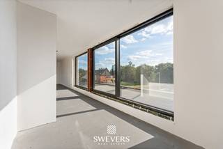 Aan de Koolmijnlaan 69 bus 2.1 in Houthalen bevindt zich deze penthouse met een bewoonbare oppervlakte van 120 m². Het appartement maakt deel uit van een nieuwbouwproject dat in 2026/2027 wordt opgeleverd en combineert, energiezuinigheid met een hedendaagse afwerking en een uiterst praktische indeling. Dankzij de aanwezigheid van een lift is dit een interessante keuze voor wie zorgeloos wil wonen en bovendien heb je hier alle nodige voorzieningen binnen handbereik. <br /><br />De leefruimte en keuken vormen samen één ruim en open geheel van maar liefst 53 m² en vormen het centrale hart van de woning. De open indeling creëert een aangename, lichte leefomgeving waarin koken, tafelen en ontspannen moeiteloos in elkaar overvloeien. De zithoek biedt met 28 m² alle ruimte voor een royale en gezellige inrichting, terwijl de keuken met 25 m² bijzonder ruim is opgevat. Hier is volop plaats voor een functionele én stijlvolle keukeninrichting met kookeiland en gezellige eethoek. Het resultaat is een open en uitnodigende leefruimte die perfect aansluit bij het dagelijkse gezinsleven, maar evengoed alle ruimte biedt om familie en vrienden te ontvangen.<br /><br />Een belangrijk pluspunt zijn de twee terrassen (28m² en 15m²). Beide sluiten naadloos aan op de leefruimte en keuken en verruimen zo de bewoonbare oppervlakte en zorgen voor een zee van lichtinval. U kan hierdoor naar eigen wens genieten van de buitenruimte op maar liefst elk moment van de dag.<br /><br />Het appartement beschikt over twee slaapkamers. De grootste slaapkamer heeft maar liefst een oppervlakte van 23 m² en biedt zo ruimte voor een groot bed, inloopdressing en/of eventueel een extra bureauhoek. De tweede slaapkamer van 12 m² is geschikt als kinderkamer, logeerkamer of thuiswerkplek. Zo blijft de indeling flexibel, ook wanneer je woonnoden later veranderen. Die flexibiliteit maakt het appartement geschikt voor verschillende levensfases.<br /><br />De badkamer is praktisch ingedeeld en sluit aan bij het hedendaagse comfort dat men van een nieuwbouwappartement verwacht. Daarnaast is er een aparte berging aanwezig. Deze ruimte is ideaal voor voorraad, poetsmateriaal, wasvoorzieningen of extra opbergmogelijkheden.<br /><br />Het gebouw is voorzien van een lift, wat het comfort verhoogt voor bewoners en bezoekers. Ook de aanwezigheid van zonnepanelen en warmtepomp is een sterk pluspunt. Ze dragen bij aan een energiezuiniger geheel en passen binnen de verwachtingen van wie vandaag bewust kiest voor een recent en toekomstgericht appartement. De kelder biedt parkeerplaatsen en bergingen aan die naar eigen wens optioneel bij aan te kopen zijn. <br /><br />De ligging aan de Koolmijnlaan in Houthalen is bijzonder functioneel. Winkels bevinden zich op ongeveer 500 meter, waardoor dagelijkse boodschappen snel geregeld zijn. Openbaar vervoer ligt op circa 180 meter en is dus vlot bereikbaar te voet. Scholen bevinden zich op ongeveer 2 kilometer, net als ontspanningsmogelijkheden en restaurants. Alles wat u vaak nodig heeft, ligt op korte afstand.<br /><br />Ook de verbinding met de ruimere omgeving is een voordeel. De snelwegen liggen op ongeveer 1,5km, waardoor verplaatsingen richting omliggende gemeenten en steden vlot verlopen. U geniet hier van de ideale centrale ligging.<br /><br />Belangrijk om te weten is bovendien dat de grondwaarde hier vastgelegd werd op €57 000. Op deze som betaal je dus slechts 12% registratierechten. Op de overige constructiewaarde van €278 000 is er 21% btw verschuldigd.<br /><br />Deze penthouse aan de Koolmijnlaan 69 bus 2.1 in Houthalen biedt 120 m² wooncomfort, twee slaapkamers, een dressing, open leefruimte, keuken met kookeiland en 2 terrassen. De nieuwbouwkwaliteit, lift, zonnepanelen, warmtepomp en gunstige ligging maken dit appartement tot een sterke keuze voor kopers die zoeken naar comfort en zorgeloos wonen. Plan een persoonlijke rondleiding en ervaar ter plaatse hoe de indeling, lichtinval en buitenruimtes aanvoelen. Voor meer informatie, bel 011 255 155. <br /><br />Prijs exclusief 21% BTW en exclusief andere belastingen en toeslagen: 335.000 euro<br />Prijs inclusief 21% BTW, exclusief andere belastingen en toeslagen: 393.380euro
