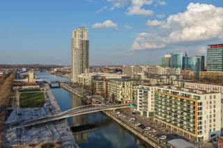 Op een uitstekende locatie aan het kanaal, recht tegenover Tour &amp; Taxis, bevindt zich dit stijlvolle en recente appartement (bouwjaar 2018) op de 2de verdieping, waar u geniet van een prachtig open zicht over het water. De ligging combineert het bruisende Brussels stadsleven met een aangename woonomgeving vlak bij parken, horeca en vlotte verbindingen naar het centrum.<br /><br />Het appartement beschikt over een lichtrijke leefruimte met massieve parketvloeren die doorlopen in de gang en de drie volwaardige slaapkamers. De open leefruimte sluit aan op een ruim terras van 28 m² met westelijke oriëntatie, waar u heerlijk kan genieten van de avondzon en het uitzicht op het kanaal.<br /><br />De volledig uitgeruste keuken is voorzien van kwalitatieve toestellen van Siemens, waaronder een inductiekookplaat, en sluit mooi aan op de leefruimte.<br /><br />Verder beschikt het appartement over drie slaapkamers, een volledig betegelde badkamer en een aparte doucheruimte, eveneens volledig betegeld tot boven. Dankzij het ventilatiesysteem D geniet u van een gezond binnenklimaat en een energiezuinige woning met PEB B. De verwarming gebeurt via gas.<br /><br />Bij het appartement dient de autostaanplaats verplicht mee aangekocht te worden aan €25.000.<br /><br />Kortom, een modern en energiezuinig appartement op een toplocatie in Brussel, met ruimte, comfort en een uitzonderlijk uitzicht.<br /><br />Interesse? Contacteer ons voor meer informatie of een bezoek.