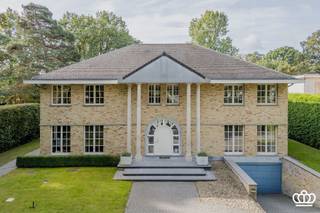 <p><span>Statische villa op absolute toplocatie te Heide-Kalmthout met onder meer ruime leefruimte, leefkeuken, 4 slaapkamers, 3 badkamers, polyvalente ruimte, bureel en ondergrondse garage voor 6 wagens gelegen op een zuidgericht privatief perceel van 2.063m² met zwembad en siervijver. </span></p><p><span> </span></p><p><span>INDELLING</span></p><p><span> </span></p><p><span>Gelijkvloers</span></p><p><span>Ruime inkomhal op natuursteen met vestiaire ruimte en gastentoilet met handenwasser. Vanuit de inkomhal rechtstreekse toegang tot de leefruimte met doorkijk naar de prachtig aangelegde tuin. De leefruimte op parketvloer is onderverdeeld in een zitgedeelte en een eetkamer met hoog plafond. De 2 aparte zitruimtes worden gescheiden door een tweezijdige gashaard. <br />Aansluitend aan de eetkamer bevindt zich de volledig uitgeruste leefkeuken voorzien van inductievuur, dampkap, oven, microgolfoven en vaatwasser. Verder is er op het gelijkvloers is een ruime slaapkamer met ingerichte badkamer voorzien van douche, wastafel en toilet. Op het gelijkvloers is een zijdeur en aparte toegang tot de kelder en naar de tuin . </span></p><p><span> </span></p><p><span>Eerste verdieping<br />De trap in de inkomhal leidt naar de eerste verdieping met lichtrijke overloop die als polyvalente ruimte fungeert. Op deze verdieping bevinden zich drie slaapkamers, elk voorzien van airconditioning, en een gedeelde badkamer met ligbad, douche, lavabo en toilet.<br />De hoofdslaapkamer beschikt over een ruime ensuite badkamer met jacuzzi, douche, dubbele lavabo, toilet en inloopdressing.<br /><br />Zolder</span></p><p><span>Via een vaste trap toegang tot de ruime zolder, momenteel ingericht als kantoorruimte maar kan ook als extra slaapkamers fungeren. Achter een wand bevindt zich een grote bergzolder die nog uitbreidingsmogelijkheden biedt.<br /><br /></span></p><p><span>Kelder</span></p><p><span> De volledige kelderverdieping is voorzien van een technische ruimte, werkplaats, wasruimte, extra berging en een sport ruimte. De ondergrondse garage biedt plaats voor 6 wagens. </span></p><p><span> </span></p><p><span>Tuin<br />Vooraan automatische toegangspoort met veel parkeergelegenheid. De privatieve tuin beschikt over een groot terras, deels overdekt met zicht op een vijver, een verwarmd zwembad met automatische overkapping en een tuinhuis met extra opslagruimte.<br />Deze villa ligt langs een mooie laan in Heide-Kalmthout. Het gezellige centrum ligt op wandelafstand, met alle nodige voorzieningen binnen handbereik. Het station biedt een vlotte verbinding naar Antwerpen, Brussel en Nederland.</span></p><p><span> </span></p><p><span>Bijzonderheden:</span></p><ul><li><span>Gelegen op wandelafstand van centrum Heide met o.a. winkels, scholen en station</span></li><li><span>Gebouwd met duurzame en kwalitatieve materialen</span></li><li><span>Ruim bewoonbaar volume</span></li><li><span>Mogelijkheid voor 6 wagens</span></li><li><span>Ideaal voor zelfstandig beroep</span></li><li><span>Veel lichtinval</span></li><li><span>Zuid-oriëntatie</span></li><li><span>Gunstig EPC</span></li></ul><p><span> </span></p>
