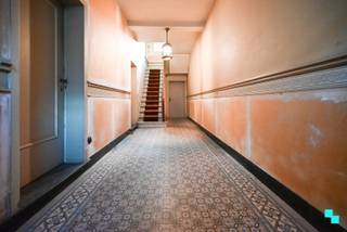 Ruime karakterwoning met potentieel en 7 kamers, gelegen op een perceel van 312 m² en met een bewoonbare oppervlakte van maar liefst 332 m² (volgens EPC-attest). Deze woning geniet een gunstige ligging nabij het centrum van Izegem, winkels, scholen en openbaar vervoer. Een ideale kans voor wie op zoek is naar een ruime woning met karakter die volledig naar eigen smaak kan worden gerenoveerd. Inkomhal met trap, voorplaats, eetplaats, leefruimte en keuken met aanpalende berging. Verder bevindt zich op het gelijkvloers een apart toilet, een kleine stadstuin en een doorrit met garagepoort (geen afgesloten garagebox). In de uitbouw is er bovendien nog een voutekamer met kelder, wat extra bergruimte of hobbyruimte biedt. Nachthal met toegang tot vier volwaardige slaapkamers en een badkamer. De zolderverdieping bestaat uit drie bijkomende kamers die tal van mogelijkheden bieden na renovatie — extra slaapkamers, bureau of hobbyruimte. Er is een kleine tuin te bereiken via de keuken, alsook is er een (verharde) open ruimte naast de uitbouw en achter de garagedoorrit die eventueel nog ingericht kan worden als tuin. Verwarming op centrale stookolie-installatie | Enkel glas in de hele woning | Compleet te renoveren | Garagepoort met doorrit naar de uitbouw / verharding | Ruime bewoonbare oppervlakte met veel indelingsmogelijkheden | EPC-label F – renovatieverplichting van toepassing. Laurence (BIV 541 501) organiseert voor deze woning de bezoeken, mits het maken van een afspraak.