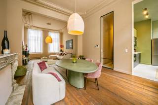 In de Keizer Karelstraat, op een bijzonder centrale ligging in Gent, bevindt zich dit uitzonderlijke duplexappartement van maar liefst 229 m², ondergebracht in een karaktervol herenhuis uit de 19de eeuw. Een eigendom waar indrukwekkende volumes, authentieke elementen en een grondige vernieuwing bijzonder mooi samenkomen.<br /><br />Het appartement strekt zich uit over het gelijkvloers en de sous-sol en werd de voorbije periode grondig vernieuwd. Zo werd een volledig nieuwe keuken geplaatst, werd de badkamer volledig vernieuwd, werden de authentieke vloeren zorgvuldig gerestaureerd en werd het volledige appartement opnieuw geschilderd. Daarbij werd bewust gekozen om het oorspronkelijke karakter van het herenhuis te bewaren.<br /><br />En dat karakter is overal aanwezig. Hoge plafonds, authentieke moluren en rozetten, karaktervolle schouwelementen, gerestaureerde vloeren en grote raampartijen geven het appartement een uitstraling die je bij nieuwbouw simpelweg niet kunt creëren.<br /><br />De bijzonder royale open leef- en eetruimte vormt het hart van het appartement. De grote volumes en plafondhoogtes zorgen hier voor een indrukwekkend ruimtegevoel. Aansluitend bevindt zich de vernieuwde keuken, vanwaar je rechtstreeks toegang hebt tot één van de buitenruimtes.<br /><br />Op de sous-sol bevinden zich vier afzonderlijke slaapkamers, waarvan de twee achterste toegang bieden tot een tweede buitenruimte. Daarnaast bevindt zich hier de volledig vernieuwde badkamer.<br /><br />Met zijn 4 tot 5 mogelijke slaapkamers en maar liefst 229 m² bewoonbare oppervlakte biedt dit appartement uitzonderlijk veel ruimte. Niet alleen voor een groot gezin, maar bijvoorbeeld ook voor wie wonen en werken wil combineren.<br /><br />Ook cohousing behoort tot de mogelijkheden. Het appartement beschikt over een conformiteitsattest voor bewoning door maximaal 10 personen. Bovendien is in elke slaapkamer reeds wateraanvoer en afvoer voorzien, wat bijkomende mogelijkheden biedt naar de toekomst toe.<br /><br />Ook het gebouw zelf krijgt verdere aandacht: de renovatie van de gevel én de renovatie van de gemeenschappelijke inkomhal zijn inbegrepen in de verkoopprijs. Hierdoor wordt niet alleen het appartement zelf, maar ook de uitstraling van het herenhuis verder opgewaardeerd.<br /><br />Wie met de wagen komt, heeft bovendien de mogelijkheid om een parkeerplaats in de omgeving te huren.<br /><br />Ook de ligging vormt een belangrijke troef. Het historische centrum, winkels, horeca, scholen en openbaar vervoer bevinden zich op wandel- en fietsafstand. De nabijgelegen Reep en Portus Ganda behoren tot een bijzonder aantrekkelijk stukje Gent langs het water. Bovendien blijft deze omgeving verder evolueren, onder meer door de geplande herontwikkeling van de Portus-site, waardoor deze zijde van de binnenstad de komende jaren nog verder wordt opgewaardeerd.<br /><br />Dit is geen doorsnee stadsappartement. Het is een eigendom voor wie op zoek is naar uitzonderlijk veel woonoppervlakte, authentieke architectuur en hedendaags comfort op een centrale locatie in Gent.<br /><br />Met 229 m², meerdere slaapkamers, twee buitenruimtes en een grondige vernieuwing biedt dit herenhuisappartement vooral iets wat in de Gentse binnenstad steeds moeilijker te vinden is: ruimte zonder het karakter te moeten opgeven.