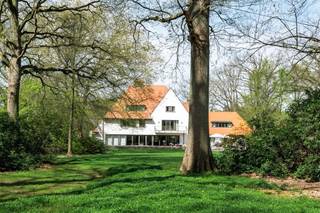 <p><span> </span></p><p><span>Deze ruime en kwalitatief afgewerkte villa is gelegen op een rustig en groen perceel en geeft comfort, privacy en snelle toegang naar alle snelwegen. De woning werd praktisch ingedeeld en biedt tal van mogelijkheden voor wonen, werken en ontspannen, zowel binnen als buiten. </span></p><p><span> </span></p><p><span>U betreedt de woning via de inkomhal met gastentoilet en directe toegang tot de bureauruimte/bibliotheek. Dit bureel is dus ideaal gelegen om mensen te ontvangen zonder dat men in de rest van de woning moet komen. </span></p><p><span>De woonkamer is zeer ruim en vormt het centrale gedeelte van de woning. Deze leefruimte biedt een prachtig panoramisch zicht over de tuin. De living werd ingedeeld met een ruime zithoek bij de open haard en formele eetplaats. Aansluitend bevindt zich de leefkeuken met ontbijtzone, welke praktisch werd ingericht en rechtstreeks verbonden is met de leefruimtes. Achter de keuken bevindt zich nog een tweede gastentoilet evenals een aparte audio- of homecinemaruimte, met daarboven een nog aparte studio. </span></p><p><span> </span></p><p><span>1e Verdieping</span></p><p><span>Via de centraal gelegen trap bereikt u de nachthal op de eerste verdieping. Hier bevindt zich een eerste ruime slaapkamer met aansluitende badkamer die gedeeld wordt met een achterliggende tweede slaapkamer. Verder is daarnaast een praktische wasplaats op deze verdieping. </span></p><p><span>De grote mastersuite beschikt over een ruime slaapkamer met aansluitende dressing (voorheen nog extra slaapkamer) en een royale badkamer voorzien van sauna en een ruime inloopdouche. Aan de voorzijde van de woning bevindt zich een studeerkamer welke ook deel uitmaakt van de mastersuite en welke eveneens dienst kan doen als een tweede dressing. Deze avond study is voorzien van een open haard.</span></p><p><span> </span></p><p><span>2e Verdieping</span></p><p><span>Ook de tweede verdieping werd volledig benut. Hier bevindt zich een bergzolder met ingemaakte kasten welke ideaal dienst doet als opbergruimte. Ook werd op de tweede verdieping een extra suite ingericht met aansluitende badkamer evenals een aparte studeer- of bibliotheekruimte. Daarnaast bevindt zich op deze verdieping nog een slaapkamer. </span></p><p><span> </span></p><p><span>Kelder</span></p><p><span>De woning is volledig onderkelderd. Hier bevinden zich diverse technische ruimtes en praktische bergruimtes. Tevens zijn er twee royale geklimatiseerde wijnkelders aanwezig. </span></p><p><span> </span></p><p><span>Garages en parkeren</span></p><p><span>Vooraan het perceel bevindt zich een ruime parkeerplaats met plaats voor circa 13 wagens evenals een carport naast de woning voor twee frequent gebruikte voertuigen, vlakbij de woning. </span></p><p><span>Achteraan het perceel, langs de oprit die aan de rand van het domein loopt, bevindt zich een afzonderlijke garage met plaats voor negen autos. </span></p><p><span> </span></p><p><span>Tuin en buitenruimtes</span></p><p><span>De tuin biedt u volledige privacy. Er is een ideaal gelegen zwembad dat recent gerenoveerd werd met ruime terrassen en aansluitend een poolhouse met leefruimte, douche, toilet en sauna. </span></p><p><span>Achteraan op het perceel bevindt zich een charmante chalet met twee slaapkamers, een keuken en een woonkamer, ideaal als gastenverblijf. </span></p><p><span> </span></p><p><span>Bijzonderheden</span></p><p><span>Deze exclusieve villa combineert royale woonruimtes met veel mogelijkheden tot ontspanning zoals zwembad, wellness en homecinema. De villa is zowel geschikt voor een groot gezin als voor een combinatie van wonen en werken. Dankzij onder meer de ruime parkeermogelijkheden, de volledig onderkelderde woning en het bijkomende gastenverblijf biedt dit eigendom een uitzonderlijk wooncomfort in een groene omgeving nabij het centrum van Brasschaat. </span></p><p><span> </span></p><p><span>Meer inlichtingen via ons kantoor.</span></p>