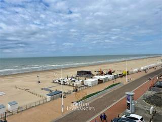 Welkom aan de Belgische kust, waar de zeelucht je elke ochtend begroet en waar rust en ontspanning samenkomen met levendigheid en comfort.<br />Op de vierde verdieping van een verzorgd gebouw aan de Zeedijk in Koksijde, wacht een charmant appartement op jou, iemand die houdt van eenvoud, karakter én een uitzicht dat nooit verveelt. Hier ervaar je compact wonen zonder in te boeten aan kwaliteit of sfeer.<br /><br />Je komt binnen via een kleine inkomhal, die het geluid van de gemeenschappelijke gang tegenhoudt, en die leidt naar een lichtrijke leefruimte met zijdelings zicht op zee – een zicht dat je instant doet vertragen. De aparte keuken, volledig vernieuwd in 2019, biedt alles wat je nodig hebt voor een ontspannen ontbijt of een zomerse lunch met zicht op het plein en de zee. De slaapkamer straalt rust uit, en de nette badkamer maakt het geheel compleet. Instapklaar? Absoluut. Zonder zorgen? Zeker weten.<br /><br />De ligging van dit appartement is ronduit uniek. Niet alleen verblijf je hier aan de Zeedijk, letterlijk op een steenworp van het strand, maar je bevindt je ook op een open plein, waardoor je geniet van een extra gevoel van ruimte. 's Ochtends wandel je in slippers naar de bakker op het gelijkvloers voor verse pistolets. Nadien een glaasje met hapjes aan de strandbar naast de deur, terwijl de kinderen zich uitleven op het speeltoestel in het zand. Of start je liever de dag sportief met de fitness-toestellen op het plein vlakbij?<br /><br />Koksijde is veel meer dan een badplaats. Het is een plek met ziel. Een dorp aan zee waar cultuur, natuur en gastronomie elkaar vinden. Denk aan de duinen van de Hoge Blekker, de stilte in natuurreservaat de Doornpanne, de gezelligheid van de kusttram, en het verrukkelijke aanbod aan restaurants en bistro’s. Hier heb je alles binnen handbereik: supermarkt, apotheek, fietsverhuur, bank en meer. En dat alles zonder dat het ooit druk aanvoelt.<br /><br />Ben jij een levensgenieter op zoek naar een tweede verblijf, een slimme investeerder of iemand die het gewoon verdient om elke dag met een glimlach naar buiten te kijken? Dan is dit je kans. Betaalbaar, instapklaar, stijlvol gerenoveerd en gelegen op een toplocatie. Een zeldzame vondst op een plek waar het altijd een beetje vakantie is.<br /><br />Nog even meegeven : het appartement beschikt over een private ondergrondse berging alsook zijn er gedeelde parkeerplaatsen beschikbaar voor eigenaars!<br /><br />Voel jij het al kriebelen? Kom dan nu ontdekken hoe wonen of verblijven aan zee écht voelt – plan vandaag nog je bezichtiging. De zee wacht op jou.<br />Zowel domicilie als 2de verblijf mogelijk !<br /><br />Vg-Wg-Gmo-Gvkr-Gvv-EPC : 226 kWh/m2 (Label C)<br />Stedenbouwkundige inlichtingen in aanvraag<br />Waterinfo : P-Score = A, G-Score = A<br /><br />Dit is niet wat je zoekt ? Al gehoord van AANKOOPBEGELEIDING ? Wij zoeken, bezoeken en onderhandelen mee met jou voor eigendommen die worden aangeboden door particulieren, andere makelaars of eigendommen die zelfs (nog) niet te koop staan?<br />Vraag meer informatie over aankoopbegeleiding via welkom@dehuisleverancier.be of 0489/069.000<br /><br />de Huisleverancier : Persoonlijk, voor iedereen Service, Kwaliteit en Vertrouwen !