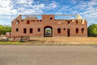 <p><span><strong>VERDER AF TE WERKEN RUIME VILLA OP LANDELIJK ZUID-WESTPERCEEL VAN 2308 M²<br /><br /><em>Onderstaande beschrijving is gebaseerd op de indeling en inrichting zoals deze voorzien was op de plannen. </em><br /><em>De woning wordt in de huidige toestand verkocht. Uiteraard kan u deze prachtige villa verder afwerken naar eigen smaak en wensen. </em><br /><br /></strong>De woning bevindt zich momenteel in ruwbouwfase en wordt verkocht in de huidige toestand. Hierdoor krijgt u als koper de unieke mogelijkheid om de woning volledig naar eigen smaak, stijl, budget en woonbehoeften af te werken.</span></p>
<p><span>De ruime oppervlaktes, de vele slaapkamers en de aanwezigheid van twee afzonderlijke leefgedeeltes met open keuken maken deze woning bovendien bijzonder geschikt voor een groot gezin, kangoeroewonen, een combinatie van wonen en werken of wie simpelweg nood heeft aan veel ruimte.</span></p>
<p><span><strong>GELIJKVLOERS</strong></span></p>
<p><span>Via de ruime inkomhal van 12 m², met gastentoilet, komt u in de eerste royale leefruimte van maar liefst 69 m², voorzien van een open keuken. Deze ruimte biedt volop mogelijkheden voor een ruime, lichtrijke leefomgeving met keuken, eetplaats en salon.</span></p>
<p><span>Verder bevinden zich op dit niveau een hobbykamer van 12 m² en een praktische berging van 9,5 m².</span></p>
<p><span>Een tweede inkomhal van 7 m², eveneens met gastentoilet, geeft toegang tot een tweede leefgedeelte van 41,5 m², opnieuw voorzien van een open keuken. Dit gedeelte beschikt daarnaast over een ruime berging van 17 m², een slaapkamer van 17,5 m² en een badkamer van 8 m² met dubbele lavabo, douche en ligbad.</span></p>
<p><span>De inpandige garage van maar liefst 32,5 m² biedt plaats aan twee wagens.</span></p>
<p><span>EERSTE VERDIEPING</span></p>
<p><span>De verdieping omvat maar liefst vijf slaapkamers, waaronder:</span></p>
<ul>
<li><span>slaapkamer 2: 14,5 m² met dressing van 11 m²</span></li>
<li><span>slaapkamer 3: 22 m²</span></li>
<li><span>slaapkamer 4: 13 m²</span></li>
<li><span>slaapkamer 5: 17,5 m²</span></li>
<li><span>bureau / slaapkamer 6: 17,5 m²</span></li>
</ul>
<p><span>Daarnaast zijn er nog twee volwaardige badkamers: een badkamer van 12 m² met douche, toilet en lavabo en een ruime badkamer van 17,5 m² met douche, ligbad en dubbele lavabo.</span></p>
<p><span>Een bijkomende berging van 11 m² vervolledigt deze verdieping.</span></p>
<p><span><strong>POSITIEVE ASPECTEN</strong></span></p>
<ul>
<li><span>Zuid-Perceel van 2.308 m²</span></li>
<li><span>Zeer ruime villa met tal van mogelijkheden</span></li>
<li><span>6 slaapkamers / bureauruimte</span></li>
<li><span>3 badkamers</span></li>
<li><span>2 afzonderlijke leefruimtes met open keuken</span></li>
<li><span>Dubbele inpandige garage</span></li>
<li><span>Nog volledig naar eigen smaak en budget af te werken</span></li>
<li><span>Ideaal voor groot gezin, kangoeroewonen of combinatie wonen/werken</span></li>
</ul>
<p><span><strong>Een uitzonderlijk ruime woning met een enorm potentieel, waarbij u als koper nog alle vrijheid heeft om het interieur volledig vorm te geven volgens uw eigen stijl en woonwensen.</strong></span></p>
<p><strong> </strong></p>
