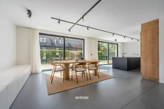 Deze stijlvolle, modernistische villa uit 2021 combineert hedendaagse architectuur met een uitzonderlijk gevoel van ruimte, licht en wooncomfort. De hoogwaardige materiaalkeuze, hoge plafonds en doordachte indeling geven de woning een tijdloze en verfijnde uitstraling.<br />De woning is centraal gelegen aan de Zestiengemeten in Drongen, op wandelafstand van het centrum van Drongen en op fietsafstand van Gent. Dankzij de vlotte verbinding met het openbaar vervoer en de nabijheid van belangrijke invalswegen geniet u hier van een uitstekende bereikbaarheid, zonder in te boeten aan wooncomfort. Via de lichtrijke inkomhal met vestiaire en gastentoilet betreedt u de woning. De royale leefruimte vormt het hart van de villa en bestaat uit een gezellige zithoek met sfeerhaard en een ruime eetplaats. Grote raampartijen zorgen voor een overvloed aan natuurlijk licht en versterken het contact met de tuin.<br />Aansluitend bevindt zich de volledig geïnstalleerde open keuken, uitgevoerd met hoogwaardige materialen en ontworpen met oog voor zowel esthetiek als functionaliteit. Een praktische was- en bergruimte biedt bijkomend comfort.<br />Een bijzondere troef is de aanwezigheid van een volwaardige slaapkamer op het gelijkvloers, voorzien van een eigen dressing en badkamer. Hierdoor is de woning ook bijzonder geschikt voor wie gelijkvloers wil wonen.<br />Op de eerste verdieping bevinden zich drie ruime slaapkamers met ingebouwde kasten, een tweede badkamer met lavabo en douche, een aparte bureauruimte en bijkomende bergruimte.<br />De tuin vormt een aangename verlenging van de leefruimtes en is voorzien van een ruim terras voor aangename buitenmomenten. Op eigen terrein is bovendien privatieve parkeergelegenheid voorzien.<br />Bijkomende troeven zijn de energiezuinigheid (EPC A) met volledige isolatie en centrale verwarming met vloerverwarming. <br />Een instapklare architecturale woning waar licht, ruimte, energiezuinigheid en hoogwaardige afwerking samenkomen op een bijzonder aangename locatie in Drongen.<br />Bel voor info, plannen of bezoek: Ulrik Willems 0495 93 38 35.