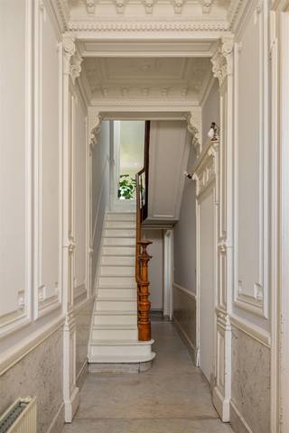 <p><span>Achter de elegante gevel van deze </span><span>neo-classicistische herenwoning</span><span> ontvouwt zich een huis waarin de charme van het verleden mooi verweven is met het leven van vandaag. De </span><span>royale inkomhal</span><span> verwelkomt met hoge plafonds, originele moulures en marmervloer. Vanaf hier ontvouwt de woning zich stap voor stap, met authentieke details die doorheen de verschillende ruimtes voor een herkenbare sfeer zorgen.</span></p><p><span> </span></p><p><span>De ruime woonkamer vormt het natuurlijke hart. </span><span>Volharde visgraatparket</span><span> </span><span>en een karaktervolle mozaïekvloer</span><span> brengen ritme en warmte en vormen samen een bijzonder knap canvas. De woonkamer loopt naadloos over in de </span><span>open volledig geïnstalleerde keuken</span><span>, terwijl grote raampartijen het daglicht diep de woning binnenbrengen. Het zicht wordt daarbij vanzelf naar achteren getrokken, richting de </span><span>groen overtrokken tuin van ca. 116 m²</span><span>. Verscholen achter de woning vormt deze idyllische buitenruimte een verrassend rustige tegenhanger van het stadsleven.</span></p><p><span> </span></p><p><span>De royale verhoudingen zetten zich verder op de verdiepingen. </span><span>Twee slaapkamers</span><span> bevinden zich op de eerste verdieping, waarvan één momenteel als ruime dressing wordt gebruikt. Op de tweede verdieping liggen nog </span><span>twee volwaardige slaapkamers</span><span>. Het tussenverdiep vormt met zijn ruime, ingerichte badkamer een vanzelfsprekende schakel tussen beide niveaus.</span></p><p><span> </span></p><p><span>Ook op praktisch vlak is deze woning bijzonder goed uitgerust. De </span><span>ruime kelder</span><span> biedt volop plaats voor voorraad en stockage. Daarnaast bestaat de mogelijkheid om op ongeveer 500 meter van de woning </span><span>een</span><span> </span><span>autostaanplaats met laadpunt</span><span> aan te kopen (€ 35.000).</span></p><p><span> </span></p><p><span>De </span><span>’s-Herenstraat</span><span> vormt ten slotte een mooie voortzetting van datzelfde verhaal. Gelegen tussen het levendige </span><span>Moorkensplein</span><span> en de karaktervolle </span><span>Zurenborgwijk</span><span>, woont u hier omringd door cafés, restaurants en lokale handelszaken. Tegelijk brengen de nabijheid van de Singel en belangrijke invalswegen u vlot naar het centrum van Antwerpen en verder.</span></p><p><span> </span></p><p><span>Een herenwoning met een sterke eigen identiteit, waar </span><span>grandeur aan de straatzijde</span><span> overgaat in warmte binnen en uiteindelijk uitmondt in </span><span>een</span><span> </span><span>groene, stille plek achteraan</span><span>.</span></p><p><span> </span></p><p><span>De beschikbare verkoopdocumenten vindt u </span><span>onderaan deze pagina</span><span>. Voor bijkomende informatie kunt u terecht via <span>thomas@urbainvastgoed.be</span></span><span> of 03 501 97 16.</span><span> </span></p><p><span> </span></p>