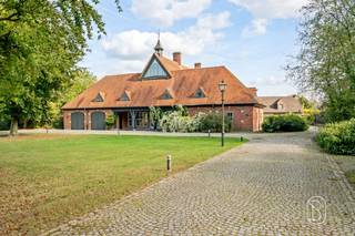 Te koop: karaktervol landhuis op ca. 5.000 m² in DeerlijkIn een groene en rustige omgeving in Deerlijk bevindt zich dit karaktervolle landhuis op een royaal perceel van ca. 5.000 m². Met een bewoonbare oppervlakte van ca. 377 m², veel privacy en tal van mogelijkheden combineert deze eigendom comfortabel wonen met ruimte voor professionele activiteiten.Wat maakt deze eigendom uniek?De woning beschikt over royale leefruimtes met grote raampartijen, waardoor natuurlijk licht en het omliggende groen overal aanwezig zijn. Warme houten vloeren, kwalitatief houtwerk en karaktervolle schouwen geven het interieur een tijdloze uitstraling. Met 4 ruime slaapkamers, een badkamer en een grote polyvalente ruimte biedt de woning bijzonder veel flexibiliteit. Deze extra ruimte leent zich uitstekend als kantoor, praktijk, hobbyruimte of voor andere professionele of private doeleinden.Buiten geniet u van een prachtig groen perceel van ca. 5.000 m², waar mature beplanting voor rust en privacy zorgt. Twee ruime garages bieden volop plaats voor wagens en opslag. Daarnaast is er ruime parkeergelegenheid, wat een belangrijke troef vormt wanneer wonen en werken gecombineerd worden.Voor wie is dit ideaal?Ideaal voor iedereen die op zoek is naar een karaktervolle eigendom met veel privacy én mogelijkheden voor wonen en werken.Te koop via Immo Beguin, jouw vastgoedexpert sinds 2009, met kantoren in Ronse, Waregem, Kortrijk, Deinze, Doornik, Lessines, Moeskroen en Nieuwpoort.