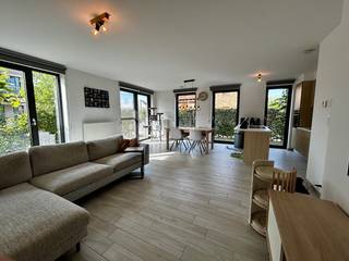LICHTRIJK GELIJKVLOERSAPPARTEMENT MET 2 SLAAPKAMERS, TERRAS, PARKING EN KELDERBERGING
Dit instapklare appartement van ca. 92 m² werd opgeleverd in 2019 en is gelegen op het gelijkvloers. Het appartement beschikt over een EPC-label A.
De ruime en lichtrijke leefruimte vormt één geheel met de eetruimte en de volledig uitgeruste open keuken. Vanuit de leefruimte is er toegang tot het westelijk georiënteerde terras van ca. 9 m².
Het appartement beschikt over twee slaapkamers van respectievelijk ca. 12 m² en 10 m². De tweede slaapkamer wordt momenteel gebruikt als bureauruimte. Verder zijn er een badkamer, een apart toilet en een praktische berging met aansluitingen voor wasmachine en droogkast.
Bij het appartement horen een ondergrondse parkeerplaats en een kelderberging. Het gebouw beschikt over een lift. De gemeenschappelijke kosten bedragen €135 per maand.
Het appartement is gunstig gelegen nabij het station van Aarschot en op wandelafstand van het centrum. Verschillende scholen en supermarkten bevinden zich in de nabije omgeving.
Interesse? Contacteer ons voor meer informatie of een bezoek ter plaatse.