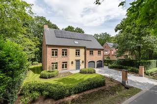 De villa & liggingDeze standingvolle villa in Kalmthout, pal aan de Kalmthoutse Heide, combineert minimalistische architectuur met modern wooncomfort. Gelegen op een groot perceel met parktuin, terras en privébos, biedt het maximale privacy. De woning beschikt over duurzame technieken (vloerverwarming, zonnepanelen, alarm) en een inpandige dubbele garage.Leefruimtes & keukenDe inkomhal leidt naar de riante, lichtrijke woonkamer. Het salon ligt verhoogd op een eiken visgraatparket rond een strakke haard. De verzonken eetzone heeft een zandstenen vloer en een erker met zicht op de tuin. Aansluitend bevindt zich de exclusieve leefkeuken in houtfineer en natuursteen, compleet met kookeiland, ontbijtbar, hoogwaardige inbouwapparatuur en directe toegang tot het terras.Slaap- & badkamersMet zes slaapkamers en drie badkamers biedt de villa optimaal comfort. Alle kamers zijn afgewerkt met eiken parket. De master suite heeft een luxe dressing en een ensuite badkamer met vrijstaand bad, dubbele regendouche en matzwart kraanwerk. De overige kamers en twee extra badkamers zijn verdeeld over de verdiepingen.Extra troevenDe royale overloop op de eerste verdieping is ingericht als open kantoor met maatwerk. Daarnaast beschikt de woning over een handige berging, technische ruimte en een grote bergzolder via een vlizotrap. Energiezuinigheid, high-end afwerking, overal ingemaakte kasten en de unieke toplocatie maken dit eigendom tot een uitzonderlijke kans van topniveau.Bestuursmaatregelen in het maatregelenregister: nee