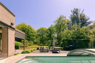 <p><span>Villa familiale exclusive avec piscine sur la Kesselse Heide.</span></p><p><span> </span></p><p><span>Cette villa familiale chaleureuse et à l'architecture bien pensée jouit d'une situation exceptionnelle en face de la magnifique Kesselse Heide, où la tranquillité, la nature et le luxe se côtoient harmonieusement.</span></p><p><span> </span></p><p><span>Ici, vous vivez au milieu de la verdure, avec un sentiment permanent de vacances, tandis que les écoles, les magasins, les transports publics et les routes de liaison ne sont qu'à une courte distance. À l'arrière, vous bénéficiez chaque jour d'une vue unique sur une nature immense et des moutons qui paissent —, une forme rare de paix et d'intimité.</span></p><p><span> </span></p><p><span>La villa a été entièrement conçue sur mesure en accordant une attention particulière à la lumière, à l'espace et à la vie de famille. De grandes fenêtres maximisent la sensation d'être à l'extérieur et créent une merveilleuse connexion entre les espaces de vie, le jardin et la piscine chauffée.</span></p><p><span> </span></p><p><span>Le cœur de la maison est la généreuse cuisine et l'espace de vie, où l'élégance et la convivialité se conjuguent parfaitement. La cuisine de haute qualité dispose de tout le confort imaginable : Quooker, four à air chaud et à vapeur, friteuse intégrée, double réfrigérateur et un garde-manger pratique. La cheminée à gaz d'ambiance complète le tableau.</span></p><p><span> </span></p><p><span>En outre, la maison dispose d'une salle de télévision/jeux séparée et d'un espace bureau élégant, qui peut être intégré ou fermé de manière flexible grâce à des portes coulissantes —, ce qui est idéal pour les familles et les bureaux à domicile.</span></p><p><span>Avec quatre chambres de taille normale, chacune équipée d'un dressing, trois salles de bains et quatre toilettes, chaque membre de la famille bénéficie d'espace et de confort. Le deuxième étage, entièrement meublé, sert actuellement de bureau, mais pourrait facilement être converti en chambres supplémentaires. La salle de sport actuelle offre également cette possibilité.</span></p><p><span> </span></p><p><span>Le sous-sol entièrement aménagé offre non seulement un espace de rangement exceptionnel, mais rend également toute la technologie parfaitement accessible.</span></p><p><span> </span></p><p><span>Rien n'a été laissé au hasard à l'extérieur non plus. La piscine chauffée, dont la terrasse et la couverture ont été rénovées, attire tous les regards. Le jardin récemment aménagé s'intègre parfaitement à la lande environnante. Pour les enfants, une cabane en bois unique avec toboggan, mur d'escalade et passerelle — les attend, un lieu où l'on se forge des souvenirs.</span></p><p><span> </span></p><p><span>Atouts supplémentaires:<br />• Label EPC A<br />• Conformité électrique<br />• 36 panneaux solaires + batterie domestique + station de charge<br />• Pompe à chaleur, chauffage par le sol & climatisation<br />• Système de ventilation D<br />• Système d'alarme, caméra’s & portail automatique<br />• Entièrement souterrain</span></p><p><span> </span></p><p><span>Une combinaison rare d'architecture, de confort familial, de durabilité et d'expérience de la nature dans un emplacement de choix à Nijlen.</span></p><p><span> </span></p>