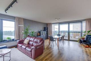 Dit appartement is gelegen op de achtste verdieping en maakt deel uit van het appartementscomplex PUNT AAN DE LAAN. Het is gebouwd in 2015-2017 en heeft een bewoonbare oppervlakte van 112 vierkante meter, plus 27 m² terrassen. De indeling is eerder klassiek met 2 slaapkamers en 1 badkamer, verbonden door een brede gang. De mooie parketvloer loopt door in nagenoeg alle ruimtes. In de living is parket en er is veel lichtinval door de grote schuiframen. De keuken is open, en aangrenzend aan de living, en is voorzien van alle toestellen. De slaapkamers zijn voldoende groot en ook in de badkamer kan je een feestje geven. Er is een grote berging, zodat je alles op 1 niveau ter beschikking hebt. <br /> <br />Het appartement is goed onderhouden en beschikt over een twee terrassen. Zowel uit de lichtrijke living, als vanuit de terrassen heb je een weids uitzicht over de velden en de groene omgeving. De moderne bouw is opgetrokken in antraciete baksteen, en heeft een luchtige uitstraling. De toegang tot het gebouw is beveiligd met een toegangscontrole systeem, wat zorgt voor extra veiligheid. <br /> In de omgeving is veel groen (met onder meer het natuurgebied Klein Zwitserland op wandelafstand) waar je kan wandelen of ontspannen. Op wandelafstand vind je ook supermarkten, frequent openbaar vervoer, scholen en het sportcentrum Het Rooi. Dankzij de nabijheid van belangrijke invalswegen heb je bovendien een vlotte verbinding naar Antwerpen, Mechelen en Brussel. <br /><br />Op het gebied van energieprestatie heeft het appartement een EPC-waarde van 93 en een energielabel A, wat betekent dat het zeer energiezuinig is. Er zijn ook vrije parkeerplaatsen beschikbaar voor het appartementscomplex, en er is een fietsenberging in de garage. <br /> <br />Kortom, dit appartement in Mortsel (dicht bij Berchem Station) biedt comfortabel wonen in een buitenstedelijke omgeving met alle nodige voorzieningen in de buurt.