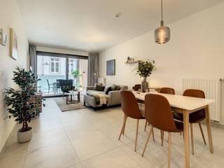 <br />Comfortabel wonen op de eerste verdieping van dit prestigieuze woonproject doe je gegarandeerd in dit appartement. Het heeft een oppervlakte van 68m² en een overdekt, zuidelijk georiënteerd terras van net geen 10m². Een topligging, want je kijkt uit op de Lombaardstraat waar veel fijne winkels liggen en je heel wat passage ziet voorbijkomen. Bovendien heeft het terras een berging, die netjes is weggewerkt in de houten wand. Tot slot zijn er ook enkele geperforeerde luiken die je open en dicht kan schuiven voor zonwering en privacy. <br /><br />Een extra troef is dat er zowel een schuifraam aan de leefruimte als aan de slaapkamer is voorzien. Die kan je tegelijk openschuiven, waardoor het appartement doorloopt in het terras. De badkamer is gelegen aan de slaapkamer en is betegeld met een licht beige vloertegel, net zoals de rest van het appartement. De keuken is wit afgewerkt met licht houten accenten. De liefhebbers kunnen bij honger (overdekt) doorlopen naar de brasserie van het Ursulinenhof. Top!<br /><br />Dit appartement is ook uiterst geschikt als opbrengsteigendom met een mooi maandelijks huurrendement.<br /> 