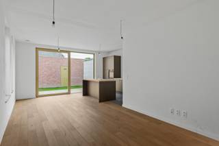 Deze charmante duplexwoning, met inkom aan de Ambachtsstraat, combineert een klassieke indeling met moderne technieken en energiezuinig comfort. <br /><br />Op het gelijkvloers vormen de volledig ingerichte keuken, eetruimte en zitplaats een open en luchtig geheel met zicht op de tuin. Een grote voorraadberging grenst aan de keuken en de technische installaties zijn netjes ondergebracht in een aparte berging.<br /><br />Achteraan bevindt zich een zuidgerichte stadstuin met ommuurd terras en een poortje naar de straat – ideaal voor privacy. Via de tuin heb je directe toegang tot een zeer ruime garage ( aan te kopen voor €40.000,-), geschikt voor een wagen, meerdere fietsen, afvalcontainers en met voorziening voor een laadpaal, aangesloten op de meter van de woning.<br /><br />Op de verdieping vinden we twee slaapkamers met parket en een comfortabele badkamer met dubbele wastafel, douche en extra toilet – perfect voor gezinnen of koppels.<br /><br />Kwaliteit en duurzaamheid gegarandeerd:<br /><br />*Vloerverwarming mét vloerkoeling, warmtepomp en zonnepanelen inbegrepen.<br />E-peil 10 (ver onder de norm), wat betekent: 5 jaar vrijstelling van onroerende voorheffing.<br /><br />Een comfortabele, energiezuinige woning op een centrale locatie – klaar om jouw thuis te worden!<br /><br />Aankoop mogelijk aan 6% BTW