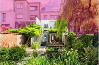 Unieke duplexwoning ontworpen door Léon Stynen<br /><br />Hier woon je uiterst centraal met een uitzonderlijk vlotte bereikbaarheid. Winkels, openbaar vervoer en grote invalswegen liggen vlakbij, en voor ontspanning zijn het Vinkenhof, Harmoniepark en Albertpark op wandelafstand. Kortom: een absolute toplocatie!<br />De woning kan zowel via de gelijkvloerse als de eerste verdieping worden betreden – ideaal voor wie een thuiskantoor of aparte ruimte nodig heeft. Op het gelijkvloers vind je een multifunctionele ruimte van ca. 67 m², een berging en een afzonderlijk toilet. De eerste verdieping is uitzonderlijk lichtrijk en biedt een prachtig zicht op de tuin. Hier bevinden zich een sfeervolle zithoek, een open ruimte (eenvoudig om te vormen tot 2 slaapkamers met badkamer), een afzonderlijk toilet, een wasplaats en de eetkamer met volledig geïnstalleerde keuken. Aansluitend ligt een zonnig terras met trap naar de tuin.<br />De absolute blikvanger is de aangelegde tuin van ca. 140 m² met veel zon, groen en een vijverpartij: een ware oase van rust midden in de stad. Verder zijn er nog een gemeenschappelijke kelder en fietsenberging.<br /><br />Bijzonderheden: <br />•Architectuur van Léon Stynen<br />•Talloze indelingsmogelijkheden<br />•Kleine mede-eigendom (slechts 1 ander appartement)<br />•Gunstige EPC-score<br />•Uitzonderlijk veel lichtinval en prachtige uitzichten<br />•Richtprijs: €765.000