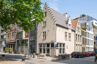 <span>In het hart van Antwerpen, op de hoek van de Koolkaai, bevindt zich dit uitzonderlijke pand: een laatgotische stadswoning uit het laatste kwart van de 15de eeuw, bekend als “Groote Schalien Loove”. Dit beschermd erfgoed werd met uiterste zorg en vakmanschap gerenoveerd, met een indrukwekkend resultaat waarbij hedendaags wooncomfort en historisch karakter naadloos samensmelten. Achter de authentieke gevel schuilt een verrassend ruime woning, verdeeld over meerdere niveaus.<br /><br />De woning telt vier slaapkamers, drie afgewerkte badkamers, een inpandige garage en twee aangename terrassen. Originele elementen zoals houten draagbalken, historische vloerpartijen en monumentale schouwen werden met respect behouden, terwijl het pand werd uitgerust met moderne technieken zoals centrale verwarming op gas, zonnepanelen en een alarmsysteem. Op de eerste verdieping trekt de indrukwekkende leefkeuken onmiddellijk de aandacht. De ruimte is afgewerkt met oog voor detail en uitgerust met een kookeiland in opvallend wit marmer, hoogwaardige inbouwtoestellen en een doordachte indeling, een ideale plek voor wie houdt van koken en gastvrijheid. Het commerciële gelijkvloers en de indrukwekkende kelderverdieping onderstrepen de degelijke bouwstructuur van het pand en bieden tal van mogelijkheden: van wijnkelder tot atelier of hobbyruimte. Een zeldzame combinatie van geschiedenis, comfort en architecturale finesse, in het hart van de stad.<br /><br />De Koolkaai bevindt zich op een toplocatie in Antwerpen, vlak bij het historische stadscentrum, het bruisende Eilandje en de vernieuwde Scheldekaaien. Deze buurt combineert het authentieke karakter van de oude haven met hedendaagse stadsvernieuwing, wat zorgt voor een unieke woonomgeving. Een ideale ligging voor wie graag leeft in het hart van de stad, met alles binnen handbereik. <br /><br />EPC kWh/(m²*a): 257 - vergunning uitgereikt, Woongebied met een culturele, historische en/of esthetische waarde, Geen rechterlijke herstelmaatregel of bestuurlijke maatregel opgelegd, Geen verkavelingsvergunning - P+G score: C<br /></span>