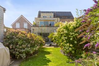 Op zoek naar een ruime en uitstekend onderhouden gezinswoning met veel mogelijkheden? Deze verzorgde bel-etagewoning in Wommelgem, gebouwd in 2005, biedt maar liefst 234 m² bewoonbare oppervlakte op een perceel van 344 m². De woning combineert royale leefruimtes met een inpandige garage, een prachtig aangelegde tuin en verschillende zonnige buitenruimtes. Op wandelafstand van Fort van Wommelgem en Kasteel Hulgenrode<br /><br />Op het gelijkvloers bevindt zich een ruime garage met plaats voor wagen, fietsen en extra bergruimte. Achterliggend werd een studio ingericht met slaapkamer en eigen badkamer. Vanuit deze ruimte heeft u rechtstreeks toegang tot de tuin die automatisch wordt geïrrigeerd. Ideaal voor een inwonend familielid, ouder kind, gastenverblijf of eventueel een zelfstandige activiteit aan huis.<br /><br />De eerste verdieping vormt het hart van de woning. Hier vindt u een ruime en lichtrijke woonkamer met op afstand bediende en geautomatiseerde verlichting binnen en buiten. De woning heeft vloerverwarming als hoofdverwarming en een design palletkachel voor sfeerwarmte in de woonkamer.<br />Aansluitend de eetkamer en open keuken. De keuken is volledig uitgerust met de nodige toestellen en biedt heel wat praktische opbergmogelijkheden. Vanuit de leefruimte heeft u toegang tot een ruim zonneterras met mooi zicht op de tuin.<br /><br />Op de tweede verdieping bevindt zich een ruime slaapkamer met aansluitende dressing. Dankzij de beschikbare ruimte kan de dressing worden opgesplitst tot een extra afzonderlijke slaapkamer. Verder is er een zeer ruime badkamer, uitgerust met ligbad met douche, dubbele lavabo en toilet.<br /><br />Ook buiten heeft deze woning heel wat te bieden. De prachtig aangelegde tuin vormt een groene en verzorgde buitenruimte waar het heerlijk vertoeven is. Aansluitend aan de woning bevindt zich een aangenaam zonneterras. Achteraan in de tuin vindt u bovendien een praktisch tuinhuis en een sfeervolle loungeruimte: de ideale plek om in alle rust te ontspannen en te genieten van lange zomeravonden.<br /><br />Troeven:<br /><br />- Bel-etagewoning uit 2005<br />- Ca. 234 m² bewoonbare oppervlakte<br />- Perceel van 344 m² met automatische irrigatie van tuin en terrassen.<br />- Studio met slaapkamer en badkamer op het gelijkvloers<br />- Lichtrijke woonkamer en eetkamer met de op afstand bediende en geautomatiseerde verlichting binnen en buiten vloerverwarming en palletkachel.<br />- Volledig uitgeruste open keuken met veel bergruimte<br />- Ruim zonneterras met zicht op de tuin<br />- Prachtig aangelegde tuin<br />- Extra terras, tuinhuis en gezellige loungeruimte<br />- Flexibele indeling met diverse mogelijkheden <br /><br />Een verrassend ruime en veelzijdige woning waar comfortabel wonen, een praktische indeling en aangenaam buitenleven perfect samenkomen. De afzonderlijke studio, royale leefruimtes en prachtig ingerichte tuin maken deze woning bijzonder aantrekkelijk voor gezinnen die nét dat beetje extra ruimte zoeken.<br /><br />Absoluut een bezoek waard!