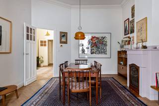 <p>Welkom op de tweede verdieping van een karaktervol gebouw waar slechts vier eigenaars wonen. Hier krijg je geen appartement met een stukje van een verdieping. Nee, de hele verdieping is van jou.</p>
<p>En dan stap je binnen... 215 m² woonplezier, plafonds van maar liefst <strong>3,60 meter hoog,</strong> prachtige <strong>visgraatparketten</strong>, authentieke elementen en een indeling die allesbehalve voorspelbaar is.</p>
<p>Het appartement werd gebouwd rond een centrale lichtkoker, waardoor alle ruimtes op een verrassende manier in elkaar overvloeien. Geen lange, donkere gang die kamers aan elkaar rijgt, maar een vloeiende indeling die telkens weer een nieuw zicht, een andere ruimte of een onverwachte hoek prijsgeeft. Het is speels, logisch en ontzettend charmant. Je wandelt als het ware een rondje door je eigen woning. Praktisch? Absoluut. Origineel? Nog veel meer.</p>
<p>Er zijn vier slaapkamers, waarvan één vandaag als dressing dienst doet, twee badkamers en verschillende leefruimtes die zich moeiteloos aanpassen aan jouw leven. Een gezellige tv-kamer, een bibliotheek, een speelkamer, een thuiskantoor,… Het kan allemaal, zonder dat iemand moet inboeten op zijn eigen plekje</p>
<p>Ook de prachtige keuken is zo'n ruimte waar vanzelf leven ontstaat. Een lange tafel, koffie die net iets te lang duurt, vrienden die blijven hangen... Precies zoals het hoort.</p>
<p>En buiten? Daar ligt één van de leukste buurten van Antwerpen aan je voeten<br />'s Ochtends wandel je naar Butchers Coffee voor je cappuccino, haal je zuurdesembrood bij Boulot, spreek je af op het Krugerplein voor een aperitief bij Bar Leon of sluit je de avond af bij Bar Chapel. Alles ligt op wandelafstand.<br /><br />Ook technisch zit alles goed. Een EPC B, conforme elektriciteit, een vernieuwde gasketel en als extraatje nog een kelderberging.</p>
<p>Er staat nog een prachtige originele lift in het gebouw. Die brengt je vandaag helaas nergens naartoe, behalve misschien even terug in de tijd... Gelukkig doet hij dat met bijzonder veel charme.<br /><br />Troeven:<br />- Volledige privéverdieping<br />- Slechts 4 eigenaars in het gebouw<br />- Authentiek karakter met plafonds van 3,60 m<br />- Prachtige visgraatparketten en originele elementen<br />- Unieke indeling<br />- 4 slaapkamers <br />- 2 badkamers<br />- Prachtige keuken<br />- EPC B<br />- AREI conform<br />- Vernieuwde gasketel<br />- Privatieve kelderberging<br />- Fietsen kunnen veilig in het gebouw geplaatst worden<br />- Gem. kosten ca. €200/maand (incl. water)<br />- Leuke ligging</p>
<p>Hier wandel je mogelijks binnen voor een bezoek... en wandel je terug buiten met verhuisplannen :-)</p>