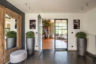<p><strong>Exclusieve split-levelvilla met 5 slaapkamers, zwembad en prachtig aangelegde tuin</strong></p>
<p>Wie op zoek is naar een woning met <strong>karakter</strong>, <strong>uitzonderlijke volumes</strong> en een <strong>unieke woonbeleving</strong>, zal onmiddellijk gecharmeerd zijn door deze <strong>indrukwekkende split-levelvilla</strong>. Dankzij haar <strong>speelse architectuur</strong>, <strong>royale leefruimtes</strong> en <strong>prachtige buitenomgeving</strong> biedt deze eigendom een <strong>zeldzame combinatie van luxe, comfort en functionaliteit</strong>.</p>
<p>Vanaf het eerste moment valt de <strong>bijzondere indeling</strong> van de woning op. De verschillende niveaus creëren een natuurlijke scheiding tussen wonen, slapen, werken en ontspannen, terwijl de open verbindingen zorgen voor een aangenaam gevoel van <strong>ruimte en licht</strong>. <strong>Grote raampartijen</strong> laten het daglicht overvloedig binnenstromen en bieden op verschillende plaatsen een prachtig zicht op de tuin en de omliggende <strong>groene omgeving</strong>.</p>
<p>Het absolute middelpunt van de woning is zonder twijfel de <strong>uitzonderlijk ruime woonkamer</strong> van maar liefst circa <strong>83 m²</strong>. Dankzij de directe toegang tot het <strong>ruime terras</strong> vloeien <strong>binnen- en buitenleven</strong> naadloos in elkaar over.</p>
<p>Een niveau hoger bevindt zich de <strong>ruime leefkeuken</strong> die perfect aansluit op de aangename eetruimte. Deze combinatie vormt het <strong>kloppende hart van het huis</strong> waar koken, tafelen en samenzijn centraal staan.</p>
<p>De villa telt maar liefst <strong>vijf volwaardige slaapkamers</strong>, verspreid over verschillende niveaus. Hierdoor geniet ieder gezinslid van voldoende <strong>privacy en comfort</strong>. De <strong>hoofdslaapkamer van circa 33 m²</strong> vormt een echte <strong>privésuite</strong> met een royaal gevoel van ruimte en rust.</p>
<p>Verder beschikt de woning over een <strong>ruime badkamer</strong> met ligbad en douche, meerdere sanitaire voorzieningen en een afzonderlijke wasruimte, wat het dagelijkse comfort aanzienlijk verhoogt.</p>
<p>Voor wie van thuis uit werkt of extra ruimte nodig heeft voor een praktijk, hobby of creatieve activiteiten, biedt de woning een <strong>uitzonderlijk ruime kantoorruimte</strong> van ongeveer <strong>31 m²</strong>.</p>
<p>Buiten ontvouwt zich een ware <strong>oase van rust en privacy</strong>. De <strong>grote, perfect onderhouden tuin</strong> vormt een groene omgeving waar jong en oud het hele jaar door kunnen genieten. Centraal in de tuin ligt het <strong>zwembad</strong>, dat tijdens de zomermaanden garant staat voor <strong>ontspanning</strong> en een echt <strong>vakantiegevoel in eigen huis</strong>. De verschillende terrassen rond de woning bieden op elk moment van de dag een aangename plek om te genieten van de zon of de schaduw.</p>
<p>De architectuur van deze split-levelvilla zorgt niet alleen voor een bijzonder ruimtelijk gevoel, maar geeft de woning ook een <strong>unieke uitstraling</strong> die haar onderscheidt van klassieke villa's.</p>
<p><strong>Troeven op een rij</strong></p>
<p>✔ Exclusieve split-levelarchitectuur<br />✔ 5 ruime slaapkamers<br />✔ Ruime kantoorruimte<br />✔ Verschillende terrassen<br />✔ Grote zolder met uitbreidingsmogelijkheden<br />✔ Perfect onderhouden en aangelegde tuin<br />✔ Verwarmd zwembad<br />✔ Veel natuurlijke lichtinval</p>
<p><strong>Een bezoek zal u zonder twijfel overtuigen van de uitzonderlijke kwaliteiten van deze eigendom.</strong></p>