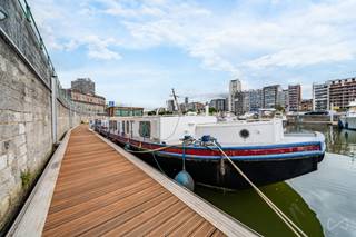 We Invest Liège, en collaboration avec Milla, a le plaisir de vous présenter à la vente cette magnifique péniche de 93,5 m², alliant charme de la vie sur l’eau et confort moderne.<br /><br />Anciennement une péniche à pont intérieur, elle a été transformée en un spacieux studio flottant, parfaitement adapté à la navigation sur les voies navigables européennes. En 2009, elle a été équipée d’un moteur IVECO puissant, facilitant la navigation fluviale.<br /><br />Caractéristiques techniques :<br /><br />-Longueur : 93,5 m²<br />- Pas de certification ES-TRIN requise grâce à ses dimensions<br />-Tirant d’air : env. 2,85 m (env. 2,00 m avec la timonerie démontée)<br />-Timonerie : équipée d’un poste de pilotage et d’un canapé<br />- Propulseur d’étrave à l’avant<br />- Nombreux espaces de rangement<br /><br />Disposition intérieure :<br />- Poste de pilotage <br />- Salle de douche avec WC, lavabo et cabine de douche<br />- Espace séjour ouvert sur une cuisine équipée<br />- Grand salon lumineux et confortable<br />- Salle des machines à l’arrière du navire<br />- Espaces de rangement disponibles à l’avant et à l’arrière<br /><br />Un bien idéal pour les amateurs de navigation ou ceux à la recherche d’un habitat original, mobile et tout confort !<br /><br />Pour plus d’informations ou organiser une visite :<br /><br />Contactez Milla Deraikem<br />- 0471/07.27.26<br />- milla.deraikem@weinvest.be<br /><br />Informations fournies à titre indicatif et non contractuelles. Cette annonce ne constitue pas une offre formelle.