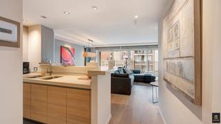 Op de Koningslaan bevindt zich dit verzorgd en lichtrijk appartement met drie slaapkamers en een westgericht terras. Danzij de brede raampartijen (6,4 m gevelbreedte) en de zonnige gevel geniet de leefruimte de hele namiddag van een mooie lichtinval. <br />De woonkamer is voorzien van vier elektrische stores met afstandsbediening, en het volledige appartement kreeg in 2024 een nieuwe LED-verlichting met talrijke dimmers voor een warme, regelbare sfeer. De open keuken met keukeneiland sluit harmonieus aan bij de eet- en zithoek.<br />Achteraan bevinden zich twee ruime slaapkamers, elk met hun eigen ensuite badkamer. De hoofdbadkamer is uitgerust met een jacuzzi voor extra comfort. De derde slaapkamer biedt plaats voor een stapelbed en een uitklapbaar bureau.<br />Daarnaast is er een aparte wasplaats met een nieuwe condensatieketel op gas (vervangen in 2022). <br />Extra troeven zijn de ingemaakte kasten, nette afwerking en het ruime westgerichte terras.