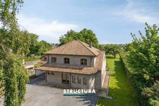 In een rustige en groene omgeving te Wemmel bevindt zich deze ruime, vrijstaande woning op een prachtig perceel van maar liefst 26a23ca. Deze eigendom combineert comfort, ruimte en privacy met een uitstekende bereikbaarheid. Dankzij de grote raampartijen geniet u hier van een overvloed aan natuurlijk licht en een aangenaam open gevoel, terwijl het zicht op het omliggende groen zorgt voor een oase van rust.IndelingDe woning verwelkomt u via een inkomhal die toegang biedt tot zowel de leefruimte als de keuken. De lichtrijke leefruimte vormt het hart van de woning en sluit naadloos aan op de eetplaats en de keuken, met directe connectie naar de tuin. Op de verdieping bevinden zich 4 slaapkamers en een badkamer, ideaal voor een gezin.Daarnaast beschikt de woning over een praktisch bijgebouw dat langs binnen bereikbaar is, bestaande uit een garage, wasberging en een extra ruimte die perfect kan dienen als bureau, hobbyruimte of extra slaapkamer.Zolder.Verschillende autostaanplaatsen voor de deur.Karakteristieken- Vrijstaande woning op perceel van 26a23ca- Bewoonbare oppervlakte: +/- 269 m²- EPC: B (energiezuinig)- Elektriciteit conform- Volledig afgesloten terrein met automatische toegangspoort- Grote oostgerichte tuin- Prachtig zicht op groen- Veel lichtinval en ruimtelijk gevoel- Bijgebouw met garage, wasberging en extra kamer/bureau- Bestuursmaatregelen in het maatregelenregister: neeBent u op zoek naar een ruime, instapklare woning met veel privacy en een groene omgeving? Dan is deze eigendom in Wemmel zeker een bezoek waard. Contacteer ons vandaag nog voor meer informatie of een bezichtiging en laat u verrassen door de troeven van deze unieke woning via 02 460 80 46 of info@structura.be