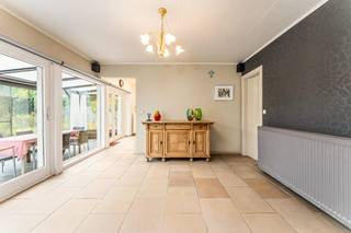 Deze goed onderhouden bungalow uit <strong>1977</strong> ligt in een rustige wijk nabij <strong>het centrum</strong>. De woning blinkt uit in haar praktische indeling en werd altijd met de grootste zorg onderhouden. Met een <strong>bewoonbare oppervlakte van 152 m²</strong> bevindt het volledige leefcomfort zich op het gelijkvloers, aangevuld met een handige eerste verdieping.<br /><br /><strong>Indeling en troeven:</strong>
<ul>
<li><strong>Gelijkvloers:</strong> Inkomhal met gastentoilet en een <strong>natuurstenen vloer </strong>die doorloopt in de keuken en de leefruimte met gezellige houtcassette. De zithoek en keuken (met fornuis, oven, frigo en vaatwas) sluiten aan op de veranda, die toegang geeft tot <strong>het zonnige terras</strong> <strong>en de tuin</strong>. Verder zijn er <strong>3 slaapkamers</strong> (in laminaat) en een badkamer met ligbad, dubbele lavabo en een tweede toilet.</li>
<li><strong>Eerste verdieping: </strong>Bereikbaar via een vaste trap en al voorzien van <strong>vernieuwde Velux-ramen</strong>. Deze ruimte onder het dak is ideaal te gebruiken als logeerkamer, hobbyruimte of extra berging.</li>
<li><strong>Garage: Dubbele garage</strong> met automatische poort en een handige regenwaterpomp.</li>
</ul>
<br /><strong>Technisch:</strong>
<ul>
<li><strong>Elektriciteit:</strong> Volledig <strong>conform!</strong></li>
<li><strong>Ramen:</strong> Grotendeels vernieuwd in <strong>PVC (2010) </strong>met rolluiken in de slaapkamers. Vernieuwde leidingen (badkamer & gastentoilet). Centrale verwarming op mazout.</li>
<li><strong>Renovatieplicht:</strong> Onderhevig aan de Vlaamse renovatieplicht (voornamelijk door het ontbreken van dakisolatie) — de ideale kans om meteen te isoleren naar eigen wens en te besparen op je energiefactuur.</li>
</ul>
<strong>Kortom, een solide en comfortabele thuis met enorm veel potentieel! Plan snel je bezoek en ontdek zelf alle troeven.</strong>