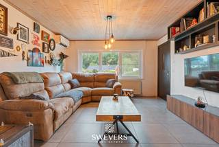 Voor meer info en foto’s, surf naar www.swevers.be – Aan de Schaffensesteenweg 80 in Paal bevindt zich deze instapklare open bebouwing met karakter, gelegen op een westelijk georiënteerd perceel van 542 m². De woning dateert uit 1954, beschikt over 184 m² bewoonbare oppervlakte en werd in 2016 grondig gerenoveerd. Dak, ramen, verwarming, elektriciteit, leidingen, keuken en badkamer werden vernieuwd. In 2021 werd ook de zolder geïsoleerd. Airconditioning en elektrische rolluiken verhogen het wooncomfort. Op het gelijkvloers bevinden zich de inkomhal, een apart toilet, een ruime leef- en eetkamer van 32 m², een aansluitende keuken van 12,48 m² en de badkamer. De veranda van 23 m² en het overdekte terras van 10,44 m² zorgen voor een aangename verbinding met de tuin. De eerste verdieping telt drie slaapkamers van 16 m², 14,40 m² en 6,38 m². Daarnaast beschikt de woning over een kelder van 7,20 m², een geïsoleerde zolder van 24,78 m² en een tuinhuis van 8 m². Dankzij de westelijke oriëntatie geniet je volop van de avondzon. Ook de ligging is praktisch: openbaar vervoer bevindt zich op circa 300 meter, scholen op 800 meter en winkels, horeca en ontspanning binnen ongeveer 1 km. De snelweg ligt op slechts 2 km. Ook de Paalse Plas, Millennium Golf, be-MINE en diverse wandel- en fietsroutes liggen in de omgeving. Voor meer informatie, bel 011 255 155. Bron bewoonbare oppervlakte: EPC – verslag.
