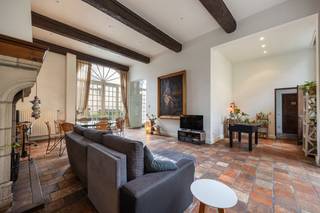 Charmant appartement in historisch 16de eeuws pand met stadstuin.<br />De grote poortdeur geeft toegang tot de gemeenschappelijke stadstuin waarlangs u naar de voordeur van het eigendom loopt. Rustig en privé gelegen in het centrum van de stad. <br />Uitzonderlijke leefruimte met open haard, hoge plafonds en veel lichtinval. De leefkeuken is voorzien van alle gebruikelijke toestellen. Via de leefruimte of de keuken bereikt men een gezellige private binnentuin. <br />De hoofdslaapkamer met ingemaakte kasten en een badkamer voorzien van dubbele wastafel, bad, douche en toilet. De tweede slaapkamer is voorzien ingemaakte kasten en een badkamer met wastafel, bad en toilet.<br />Dit appartement beschikt over een kelder. Een autostaanplaats wordt te koop aangeboden in combinatie met het appartement voor 40.000 euro.