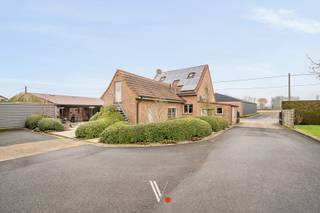 Rustig en landelijk gelegen alleenstaande woning op een perceel van bijna 4.000 m² in agrarisch gebied. Deze eigendom combineert ruimte, privacy en veelzijdige opslagmogelijkheden in een groene, serene omgeving.<br /><br />De woning is asbestveilig en uitgerust met maar liefst 48 zonnepanelen, wat bijdraagt aan een energiezuinig en toekomstgericht wooncomfort.<br /><br /><strong>Indeling woning</strong><br /><strong>Gelijkvloers:</strong> inkomhal met gastentoilet, lichtrijke woonkamer, keuken met aansluitende veranda, wasplaats en garage.<br /><strong>Eerste verdieping:</strong> 3 volwaardige slaapkamers en een hobbyruimte (of extra slaapkamer).<br /><br />Naast de woning omvat het geheel meerdere functionele bijgebouwen: een bergplaats, een klein magazijn en een bijkomend gebouw ingericht als opbergruimte met kantoorruimte. Alle opbergplaatsen zijn uitsluitend bestemd voor stockage; er mag geen activiteit plaatsvinden.<br /><br />Een unieke opportuniteit voor wie rustig wil wonen met uitzonderlijk veel ruimte en praktische opslagmogelijkheden.<br /><br /><strong>Beschikbaarheid:</strong> in overleg, najaar 2026.